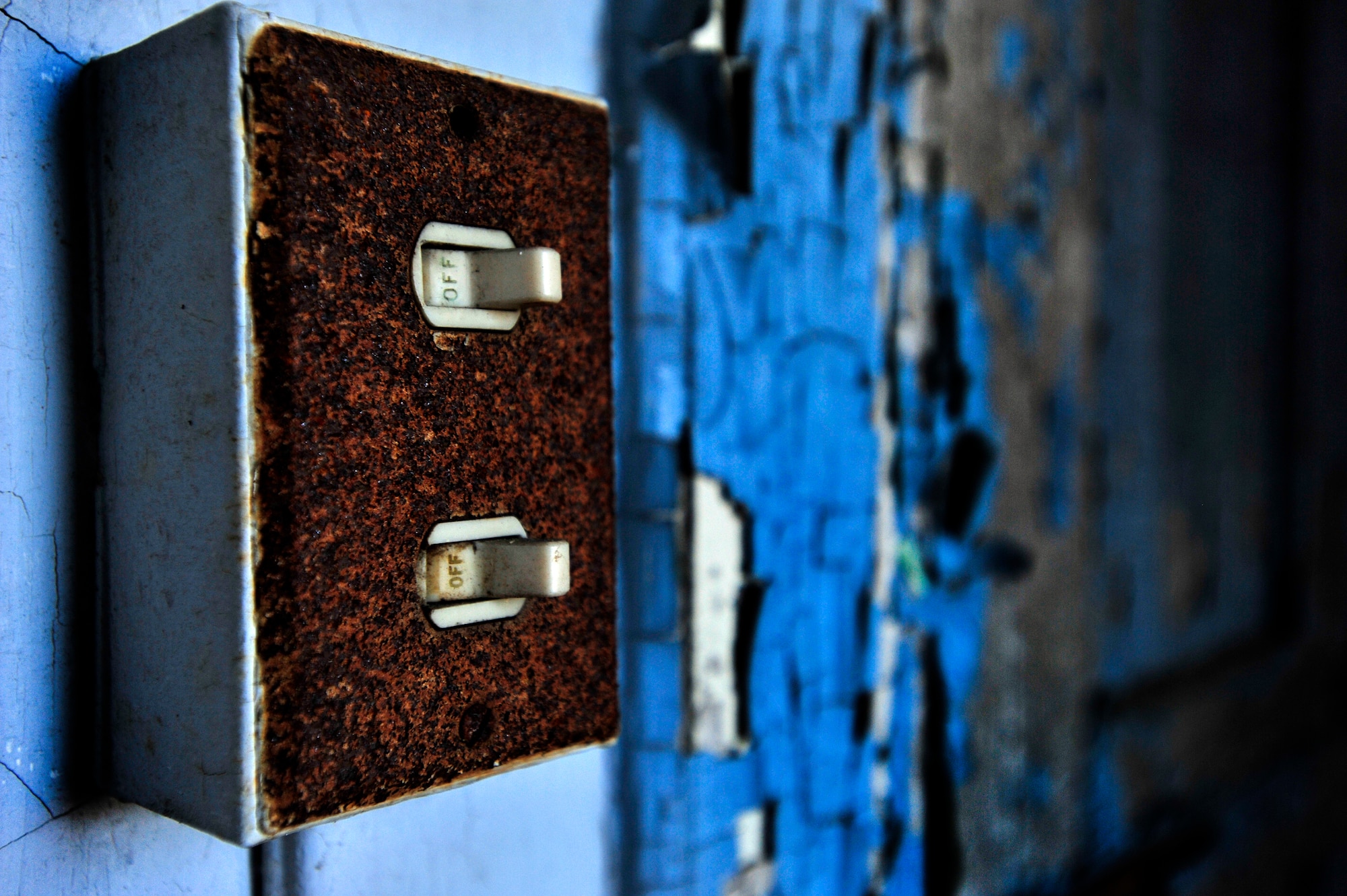 Old, rusted light switches are left in the off position after several years of use, Oct. 20, 2012, Columbia, S.C. The month of October marks National Energy Action Month, which encourages people to conserve energy. One way to aid in the conservation of energy is simply ensuring light switches are turned off when not in use. The switch in this image is located in an abandon insane asylum and no longer consumes energy as the power to the building has been turned off. (U.S. Air Force photo by Staff Sgt. Kenny Holston/Released)