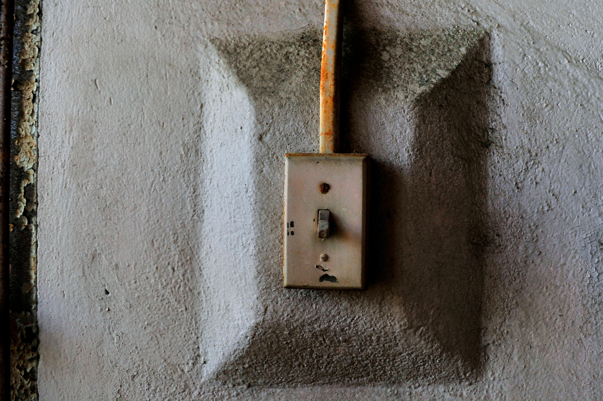 An old, weathered light switch is left in the off position after several years of use, Oct. 20, 2012, Columbia, S.C. The month of October marks National Energy Action Month, which encourages people to conserve energy. One way to aid in the conservation of energy is simply ensuring light switches are turned off when not in use. The switch in this image is located in an abandon insane asylum and no longer consumes energy as the power to the building has been turned off. (U.S. Air Force photo by Staff Sgt. Kenny Holston/Released)