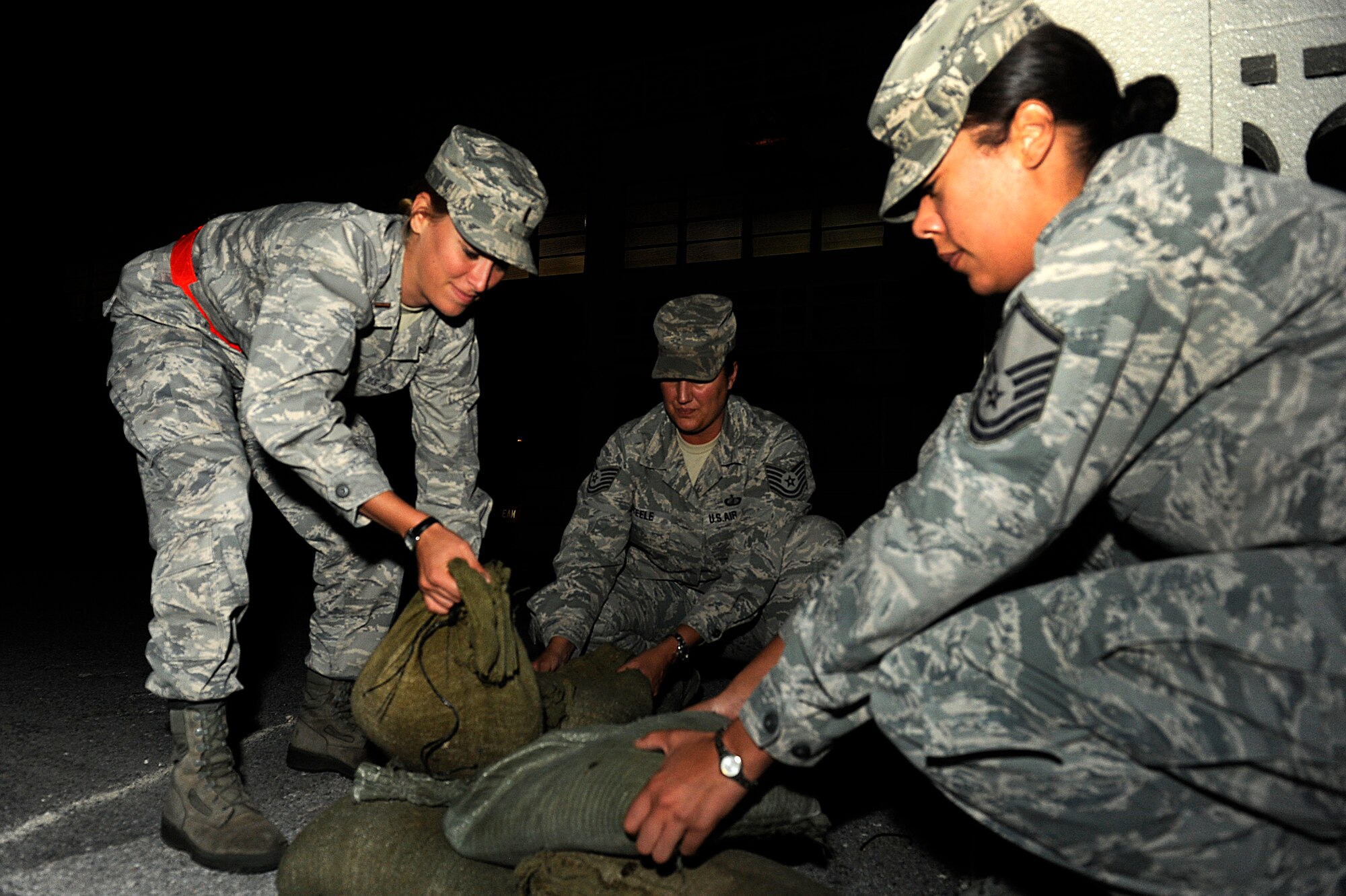 (From left to right) U.S. Air Force 2nd Lt. Allison Paddock, Tech. Sgt. Priscilla Steele and Master Sgt. Melanie Townsend, all members of the 18th Comptroller Squadron, set out sand bags to simulate splinter-proofing their facility during Exercise Beverly Bearcat 12-1, an operational readiness inspection on Kadena Air Base, Japan, Oct. 24, 2012. During exercises, Airmen are put through various scenarios, including chemical attacks, active shooter exercises and hardening a facility, in order to test their ability to survive and operate in a hostile environment. Townsend said though Airmen on Kadena are being inspected, they need to remember that performing in exercises is vital to preparing them for potential real-world scenarios in the future. “Being able to perform in this environment shows the world that we’re ready to take on the fight, if necessary, and show we’re capable as a team,” Townsend said. 