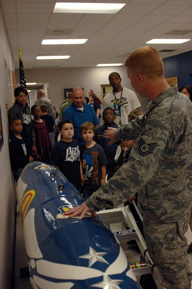 Tech. Sgt. Caleb Nicholas, currently assigned to 20th Maintenance Operation Squadron and the Cub Scout tigers den leader, shows Cub Scout Pack 320 the travel pod of Lt. Col. Christopher Claus, 55th Fighter Squadron commander, during a tour of the flight line at Shaw Air Force Base, S.C., Oct. 16, 2012. Travel pods are attached to F-16 Fighting Falcons and they hold maintenance equipment and the gear of the pilots for long trips.(U.S. Air Force photo by Airman 1st Class Krystal M. Jeffers/Released)