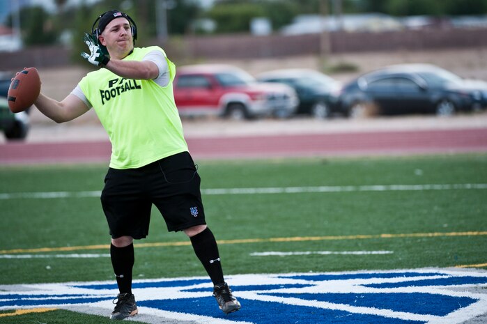 Senior Airman Daniel Hughes, 99th Air Base Wing Public Affairs, still photographer, warms up before a football game Oct. 15, 2012, at Nellis Air Force Base, Nev. There are more than 20 flag football teams from Nellis Air Force Base and Creech Air Force Base participating in the 2012 intramural flag football season.  (U.S. Air Force photo by Airman 1st Class Jason Couillard)