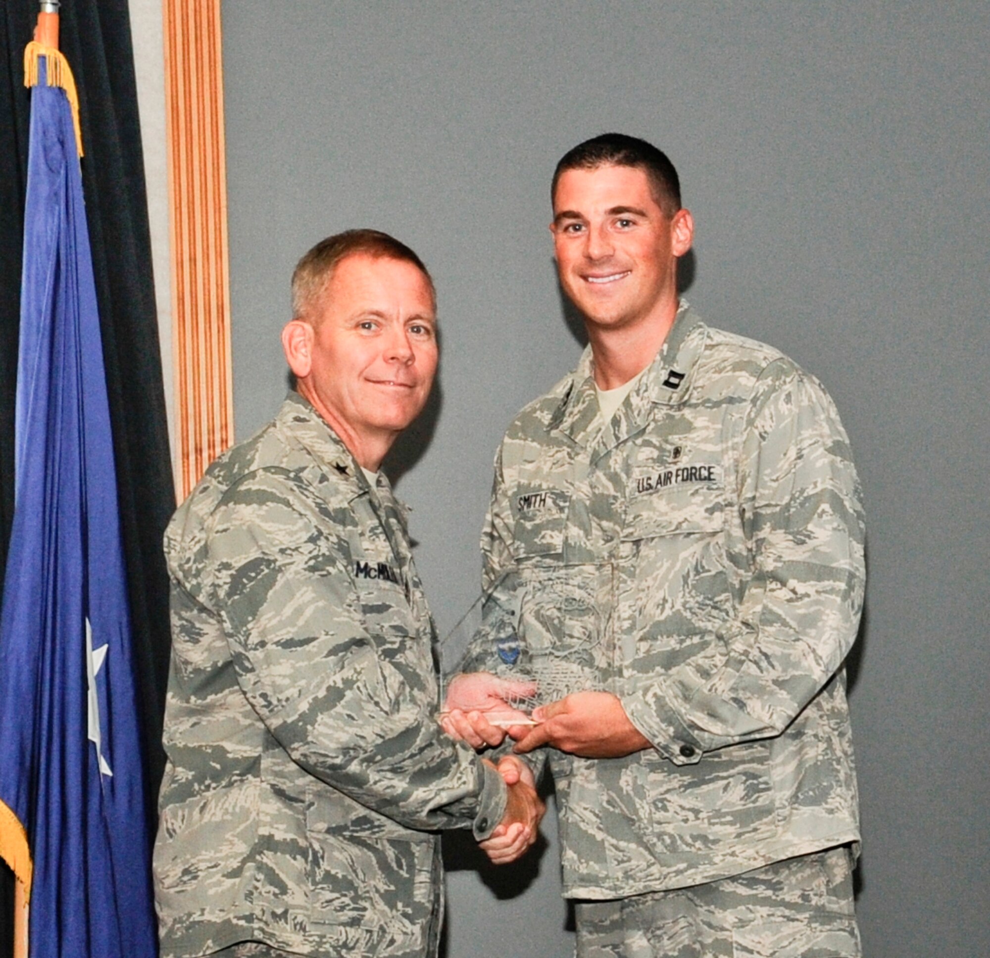 Brigadier Gen. John McMullen, 325th Fighter Wing commander presents Capt. Blake Smith, previous 325th Medical Support Squadron medical logistics flight commander, the Medical Logistics Small Account of the Year award. 
