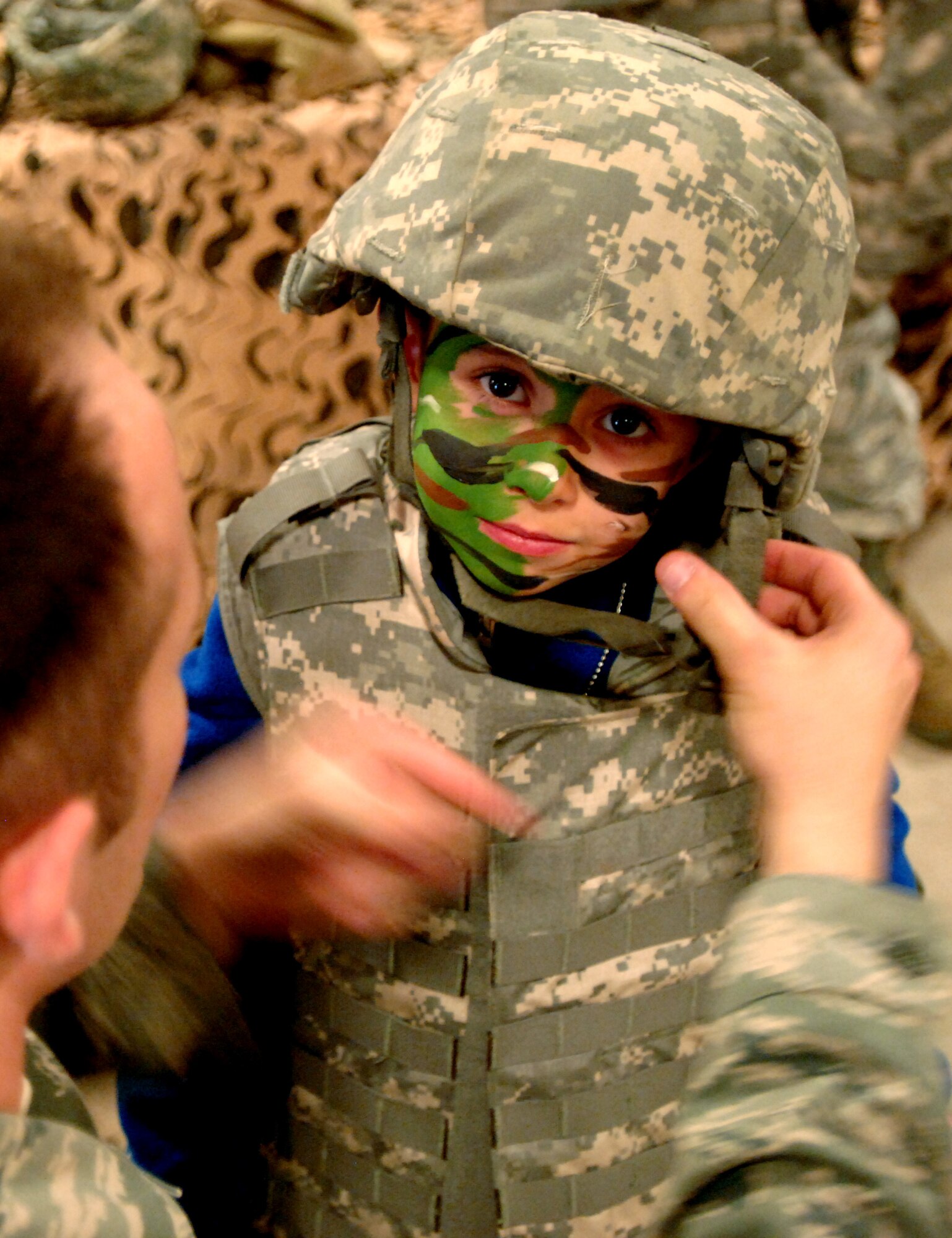 Keiyan Moreno, 6, gets fitted for a flak jacket and helmet at the Family Deployment Line on Grand Forks Air Force Base, N.D., on Oct. 20, 2012. Nearly 250 family members got a glimpse of life as a deployed Airman through the event, sponsored by the Airman & Family Services Flight. The purpose of the event was to give families the opportunity to show children ages 3-16 a firsthand look at what Airmen experience when preparing for a deployment. (U.S. Air Force photo/Senior Airman Susan L. Davis)