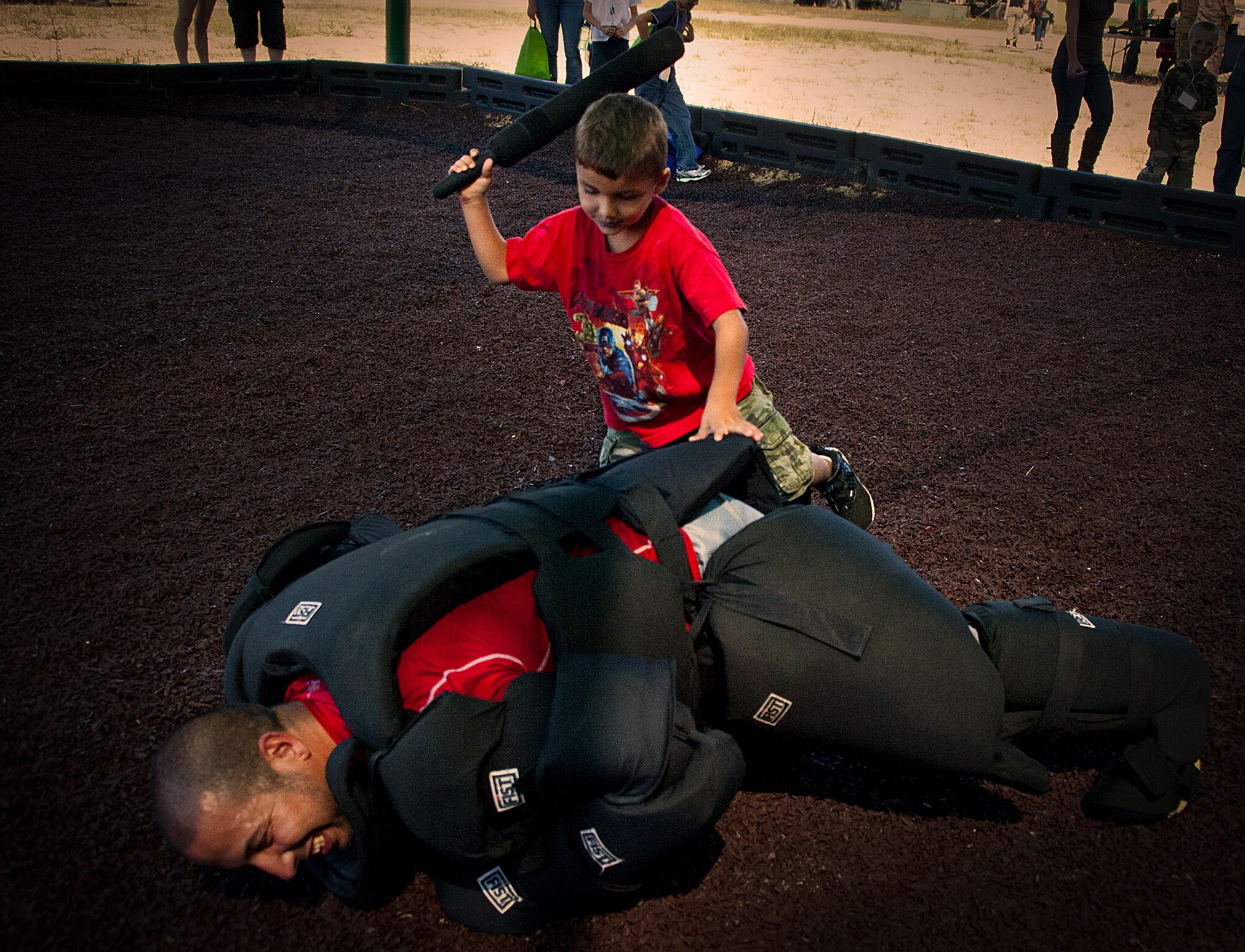 Joey Ruiz, 96th Test Wing Security Forces Squadron, is brought to the ground by his son, Xavier, in the hand-to-hand combat pit during Operation Hero at Eglin Air Force Base, Fla., Oct. 20. The event, sponsored by the 96th Test Wing Airman and Family Readiness Center, teaches children the experiences their military family members go through during predeployment and while out in the field. (U.S. Air Force photo/Randy Gon)