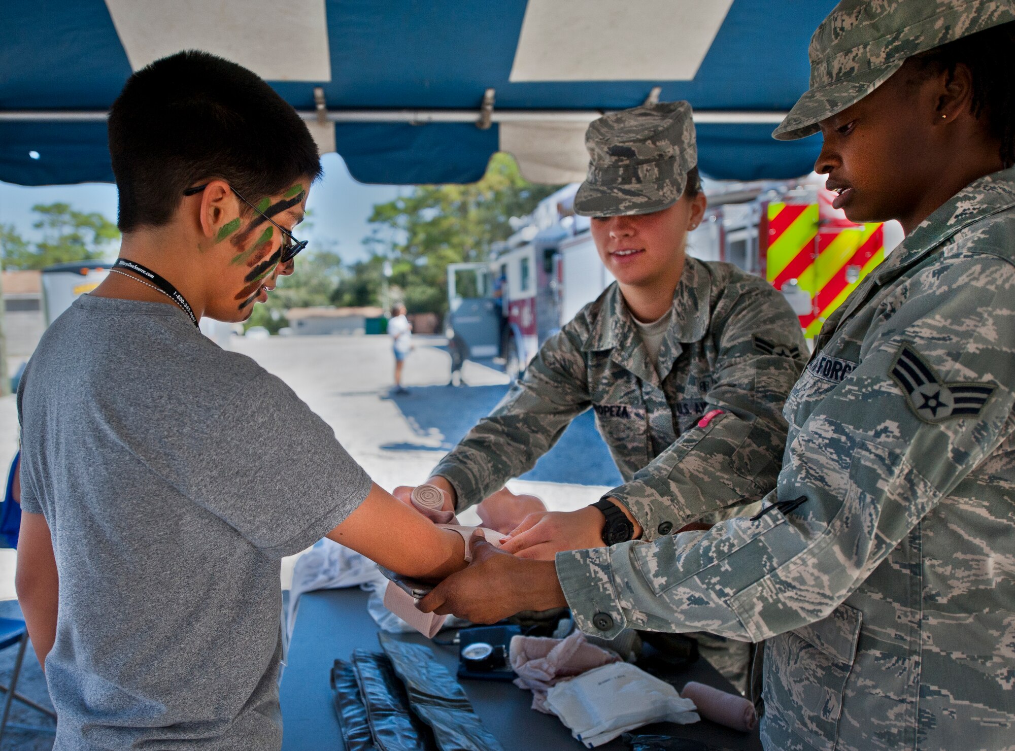 Max Valencia, son of Master Sgt. Charley Valencia, 33rd Fighter Wing Aircraft Maintenance Squadron, is given Self Aid Buddy Care hands-on training by Airmen during Operation Hero at Eglin Air Force Base, Fla., Oct. 20. The event, sponsored by the 96th Test Wing Airman and Family Readiness Center, teaches children the experiences their military family members go through during predeployment and while out in the field. (U.S. Air Force photo/Randy Gon)