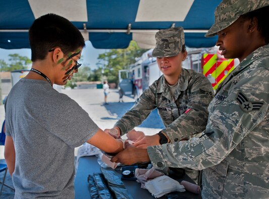Max Valencia, son of Master Sgt. Charley Valencia, 33rd Fighter Wing Aircraft Maintenance Squadron, is given Self Aid Buddy Care hands-on training by Airmen during Operation Hero at Eglin Air Force Base, Fla., Oct. 20. The event, sponsored by the 96th Test Wing Airman and Family Readiness Center, teaches children the experiences their military family members go through during predeployment and while out in the field. (U.S. Air Force photo/Randy Gon)