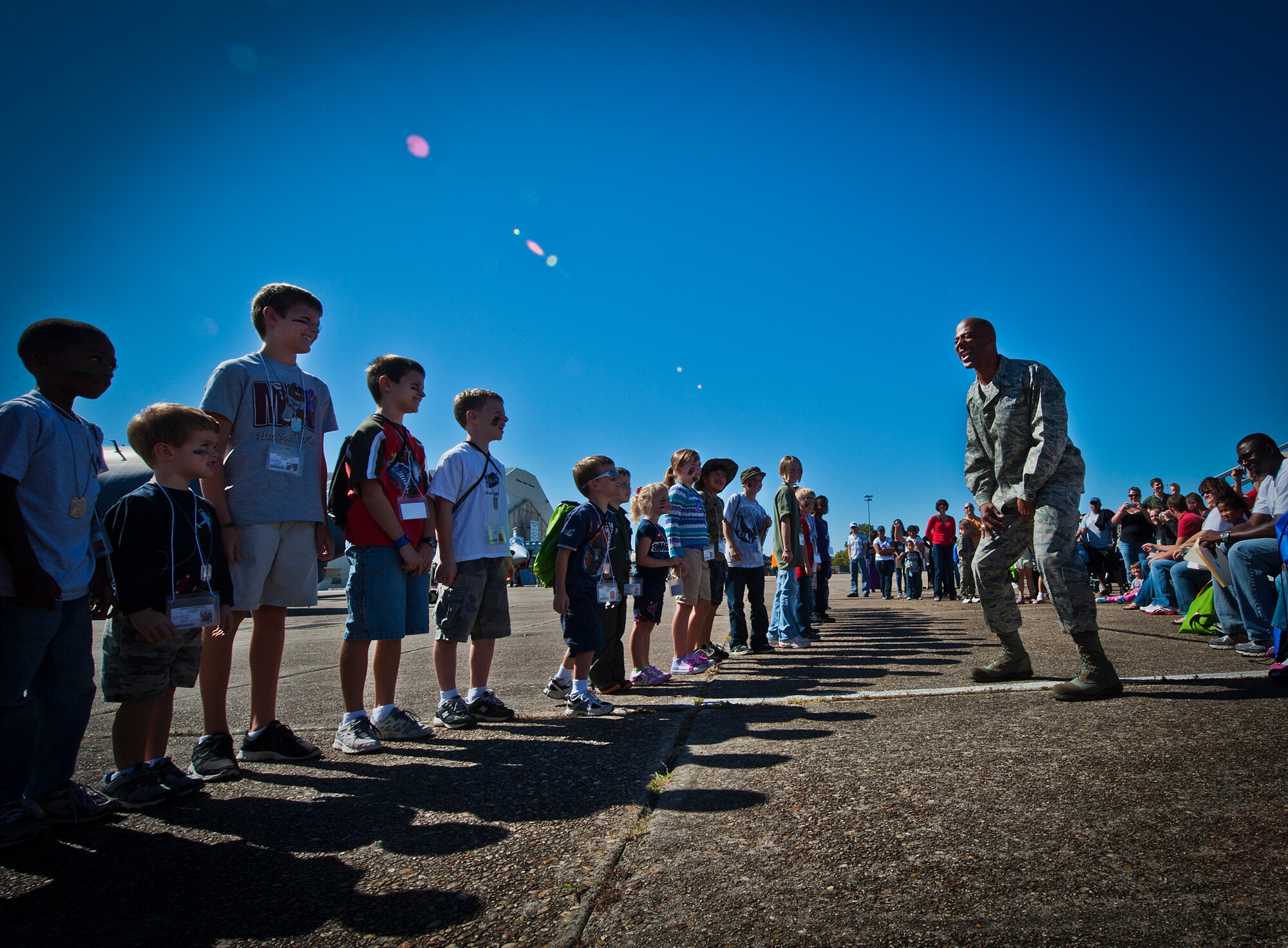 Col. Tony Douglas, 96th Test Wing installation deputy commander, encourages children to prepare for push-ups at their last stage of the processing line during Operation Hero at Eglin Air Force Base, Fla., Oct. 20. The event, sponsored by the 96th Test Wing Airman and Family Readiness Center, teaches children the experiences their military family members go through during predeployment and while out in the field. (U.S. Air Force photo/Randy Gon)