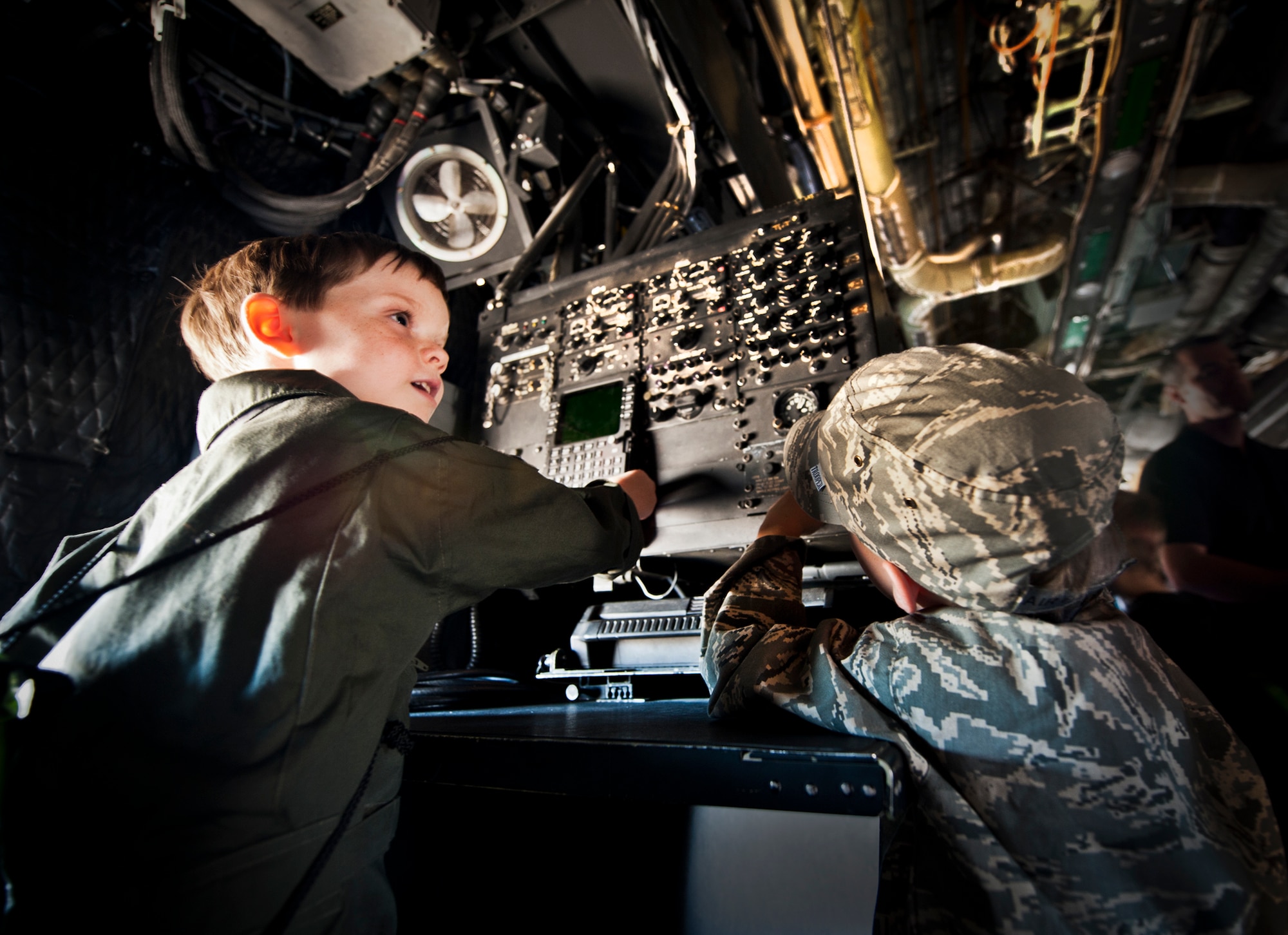 Corbin Follmar watches his brother, Graedin, operate a station on board a static C-130 aircraft during Operation Hero at Eglin Air Force Base, Fla., Oct. 20. The boys' mother, Master Sgt. Erika Follmar, is assigned to the 96th Test Wing's staff agency. The event, sponsored by the 96th Test Wing Airman and Family Readiness Center, teaches children the experiences their military family members go through during predeployment and while out in the field. (U.S. Air Force photo/Randy Gon)