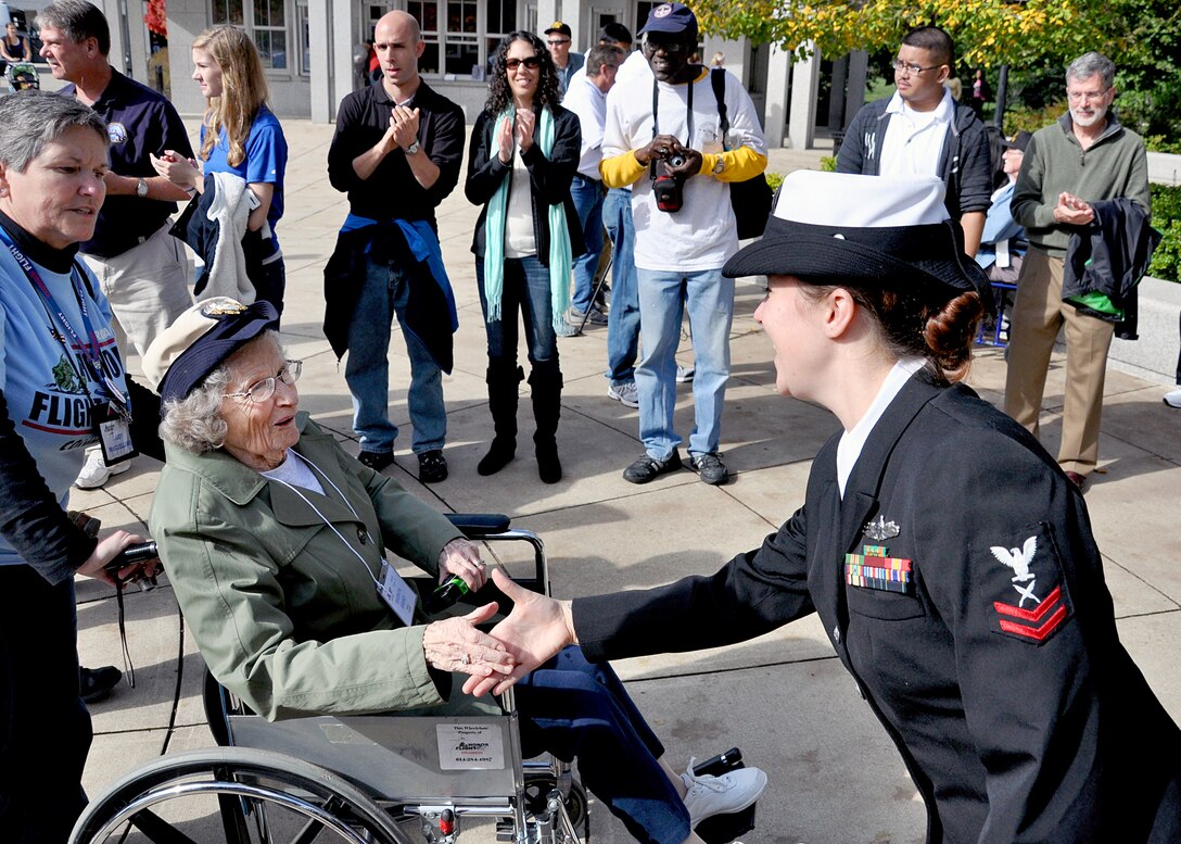 Yeoman 2nd Class Erika Cash, assigned to Military Sealift Command, shakes the hand of a World War II veteran as she enters the World War II Memorial in downtown Washington, D.C., Oct. 20 during the Joint Services Make a Difference Day. Approximately 525 veterans participated in the Honor Flight Network program, which transports America's veterans to Washington, D.C. to visit those memorials dedicated to honor their service and sacrifices. (U.S. Navy photo by Mass Communication Specialist 2nd Class Kiona Miller)