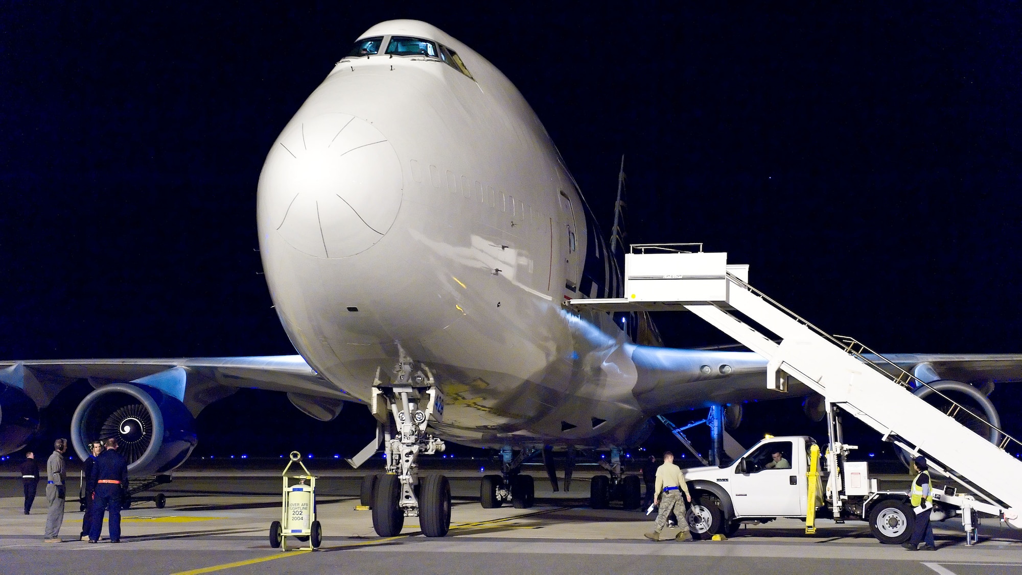 Members of the 436th Aircraft Maintenance Squadron?s Transient Alert Section and 436th Aerial Port Squadron prepare to service a Boeing 747 Oct. 21, 2012, at Dover Air Force Base, Del. Aircraft maintainers and aerial porters work in unison to ensure the quick turn-around of military and civilian aircraft at all hours of the night. (U.S. Air Force photo by Roland Balik)