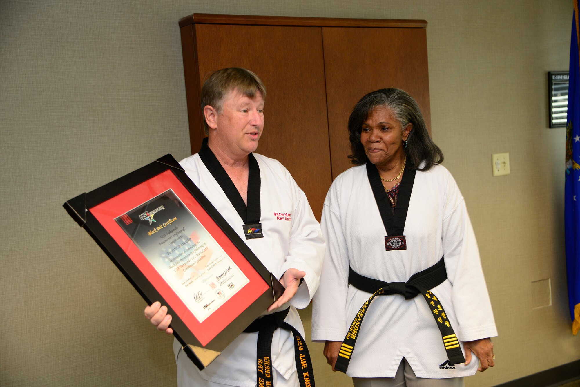 Grand Master Ray Smith, 8th degree Taekwondo black belt, presents the official USA Taekwondo honorary black belt certificate to Rose Alexander, 628th Air Base Wing chief of external information, at Joint Base Charleston – Air Base, S.C. Oct. 22, 2012. USA Taekwondo is a nationally recognized organization and affiliate of the U.S. Olympic team.  (U.S. Air Force photo / Staff Sgt. Rasheen Douglas)