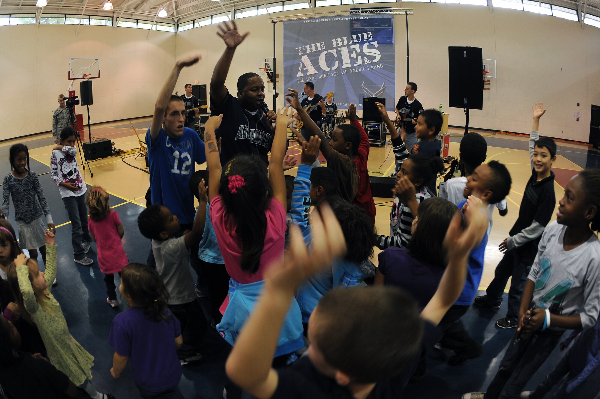Team Seymour youth throw their hands up during the Blue Aces performance at the youth center on Seymour Johnson Air Force Base, N.C., Oct. 17, 2012. The Air Combat Command band plays for military members and their families both stateside and overseas. (U.S. Air Force photo/Airman 1st Class John Nieves Camacho/Released)