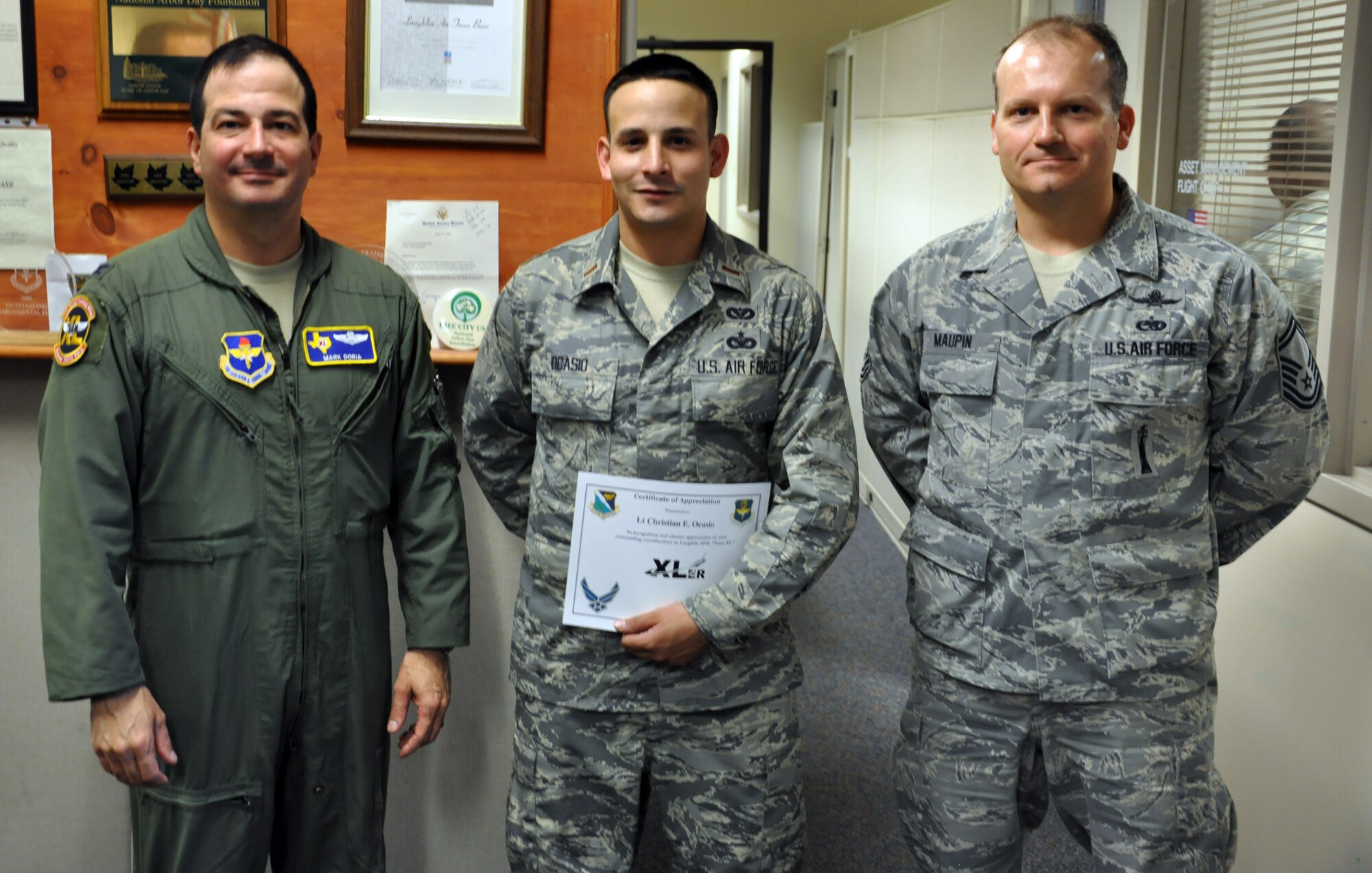 2nd Lt. Christian Ocasio, 47th Civil Engineer Squadron utilities engineer, poses with Col. Mark Doria, 47th Flying Training Wing vice commander, and Senior Master Sgt. Shane Maupin, 47th Mission Support Group superintendent, after being presented the XLer of the week award at Laughlin Air Force Base, Texas, Oct. 17, 2012. The XLer is a weekly award chosen by wing leadership and given to those who consistently make outstanding contributions to Laughlin and their unit. (U.S. Air Force photo/2nd Lt. David Tart)