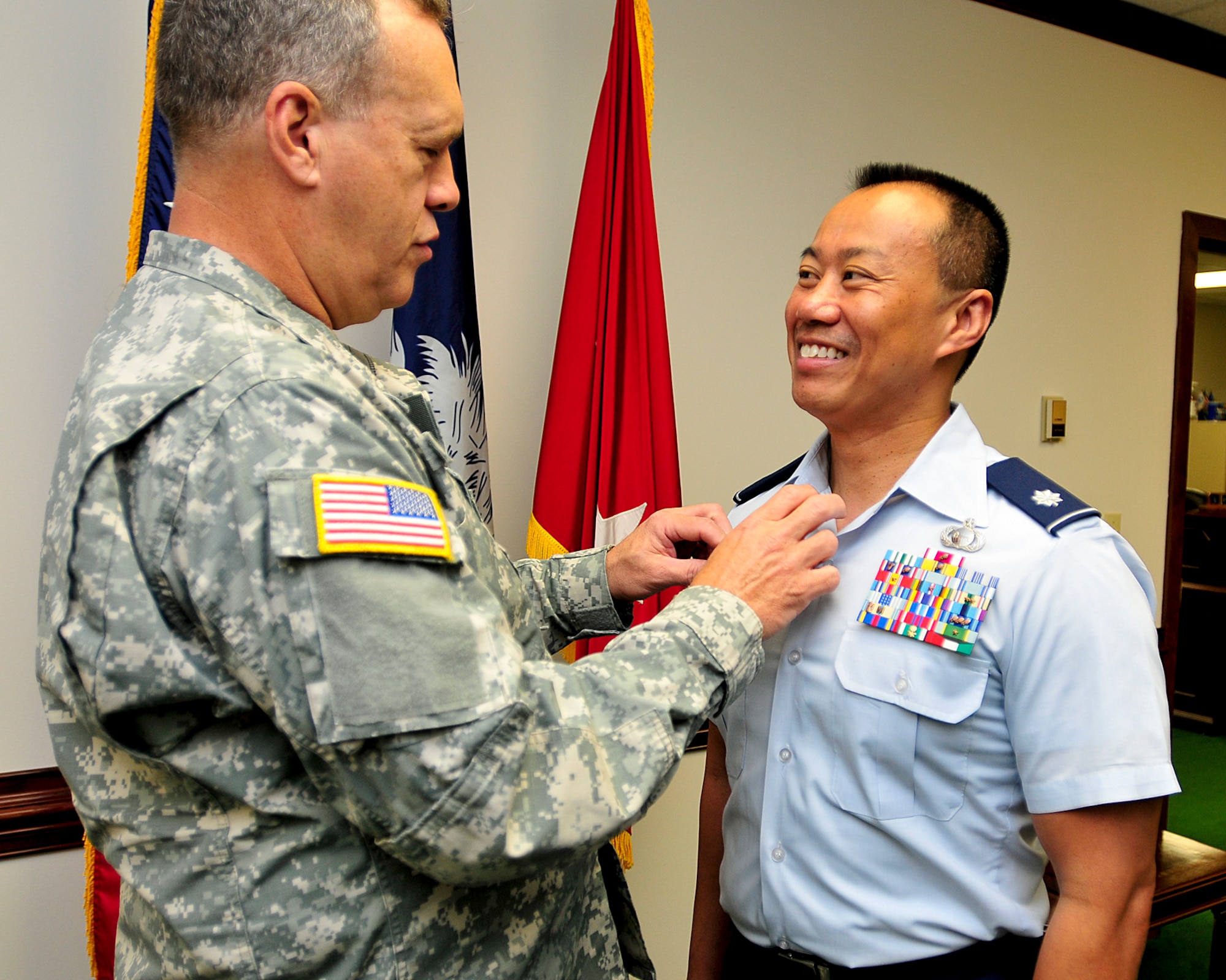 Deputy Adjutant General, Maj.Gen. Lester Eisner presents Lt. Col. Guy Alexander with his commander's pin in a ceremony held at the Adjutant General's headquarters in Columbia on Oct. 5, 2012. Alexander, formerly the Deputy J-2 for the Joint Force Headquarters, transferred to the Tennessee Air National Guard last month and is the new commander for the 247th Intelligence Squadron at the 118th Wing in Nashville.  His new squadron will be involved in Digital Network Intelligence and will execute tasks relative to the cyber domain.  (National Guard photo by Staff Sgt. Jorge Intriago/Released)