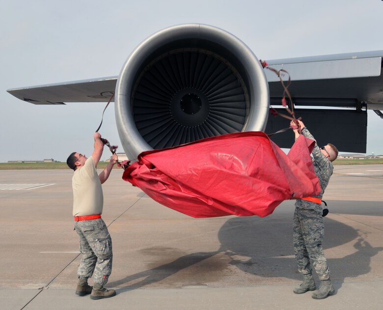 Senior Airman Stephen Reeves and Tech. Sgt. Steve Peterson, both jet propulsion mechanics assigned to the Air Force Reserve 931st Aircraft Maintenance Squadron, place an inlet cover on one of the engines of a KC-135 Stratotanker on the flightline at McConnell Air Force Base, Kan., Oct. 22, 2012.  Inlet covers are placed on the engines to protect them from being damaged while not in use.  (U.S. Air Force photo by 1st Lt. Zach Anderson)