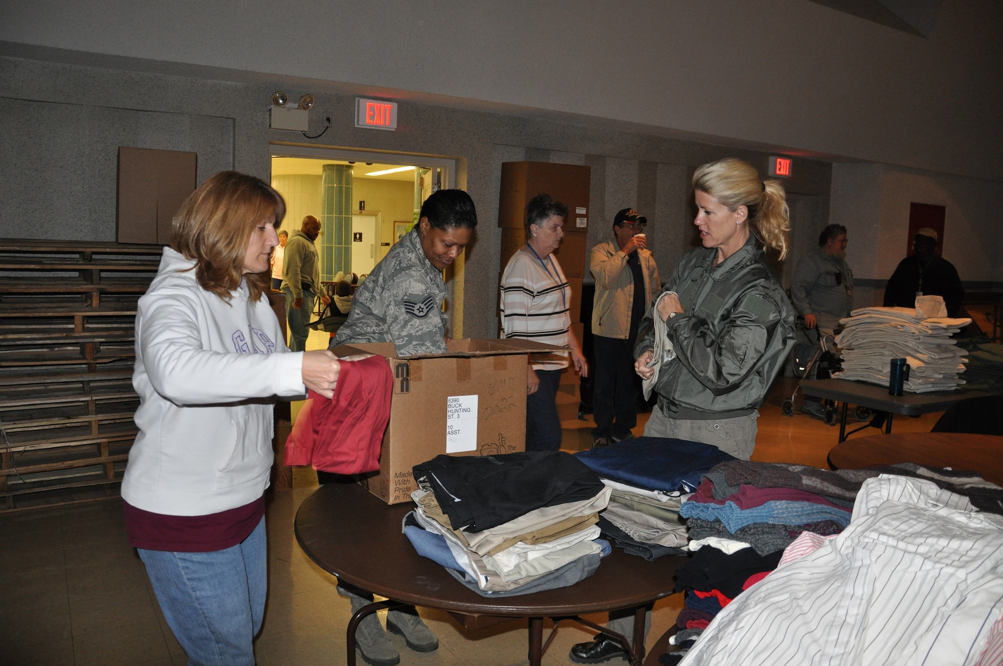 WRIGHT-PATTERSON AIR FORCE BASE, Ohio - From left to right, Tech. Sgt. Eugenie Hinson, 445th Airlift Wing historian craftsman, Staff Sgt. Jawahna Hollins, 445th Airlift Wing executive assistant to the command chief, and Senior Master Sgt. Kelly Janus, 445th Aerospace Medicine Squadron medical services technician, unpack and sort through clothing items, organizing them by type and size in preparation for the 2012 Dayton Veteran’s Affairs Homeless Stand Down Oct. 19 held at the Dayton VA Medical Center. More than 20 volunteers from the wing along with the VA staff helped more than 300 homeless veterans by handing out donated clothing items and visiting with the men and women that came through the line. (U.S. Air Force photo/Lt. Col. Cynthia Harris)