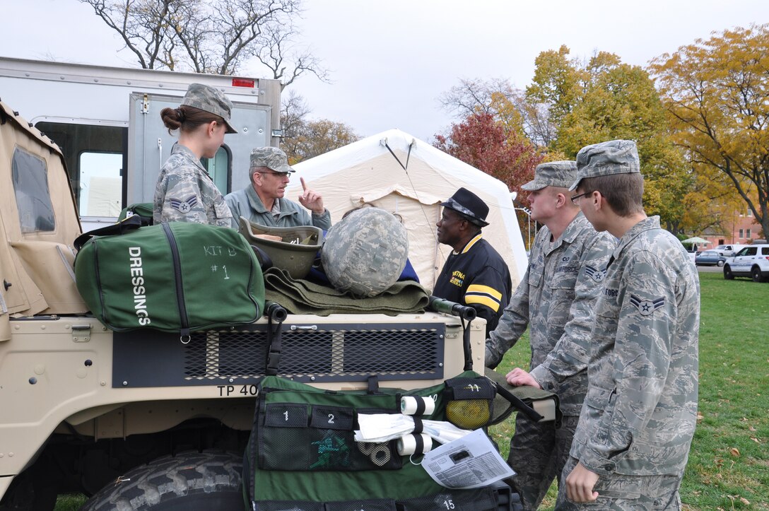 WRIGHT-PATTERSON AIR FORCE BASE, Ohio - From left to right, Senior Airman Brenna Pogoy and Chief Master Sgt. Brian Fowle, both from the 445th Aeromedical Evacuation Squadron, along with Senior Airman Brantley Fowle and Airman 1st Class Michael Petersen, both from the 445th Operations Support Squadron, explain the mission of AES to a veteran attending the 2012 Dayton Veteran’s Affairs Homeless Stand Down Oct. 19 held at the Dayton VA Medical Center. More than 20 volunteers from the wing along with the VA staff helped more than 300 homeless veterans by handing out donated clothing items and visiting with the men and women that came through the line. (U.S. Air Force photo/Lt. Col. Cynthia Harris)
