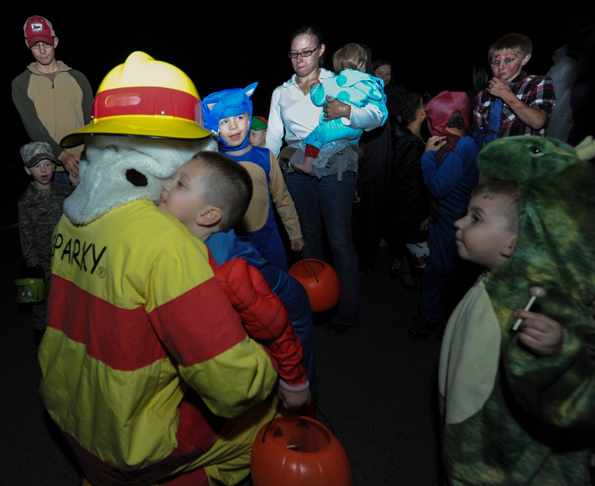 Sparky the mascot, hugs and interacts with kids during a trunk or treat event Oct. 22, 2012, at Little Rock Air Force Base, Ark. The trunk or treat event was held as a fun alternative for military families looking to trick or treat in a safe environment. (U.S. Air Force photo by Airman 1st Class Rusty Frank)