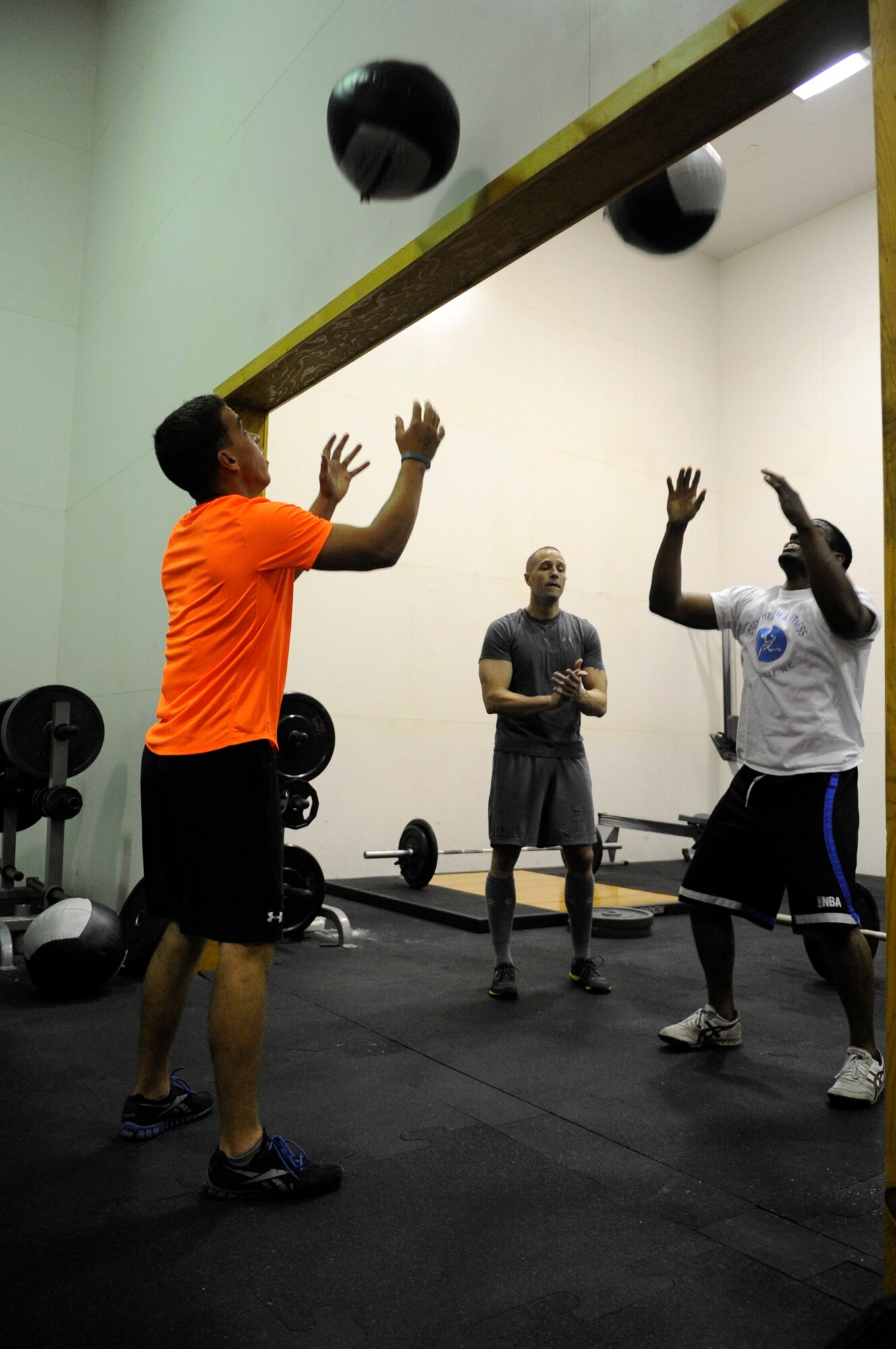 Senior Airman Mike Ray, left, 8th Security Forces Squadron, and another CrossFitter go strong as Tech. Sgt. Steven Lathem, 8th Operations Support Squadron, takes a break during the “Grace meets Kelly” CrossFit workout Oct. 20. 2012, at Kunsan Air Base, Republic of Korea. The workout was held to highlight Breast Cancer Awareness Month, which is every October. (U.S. Air Force photo/Senior Airman Brigitte N. Brantley)