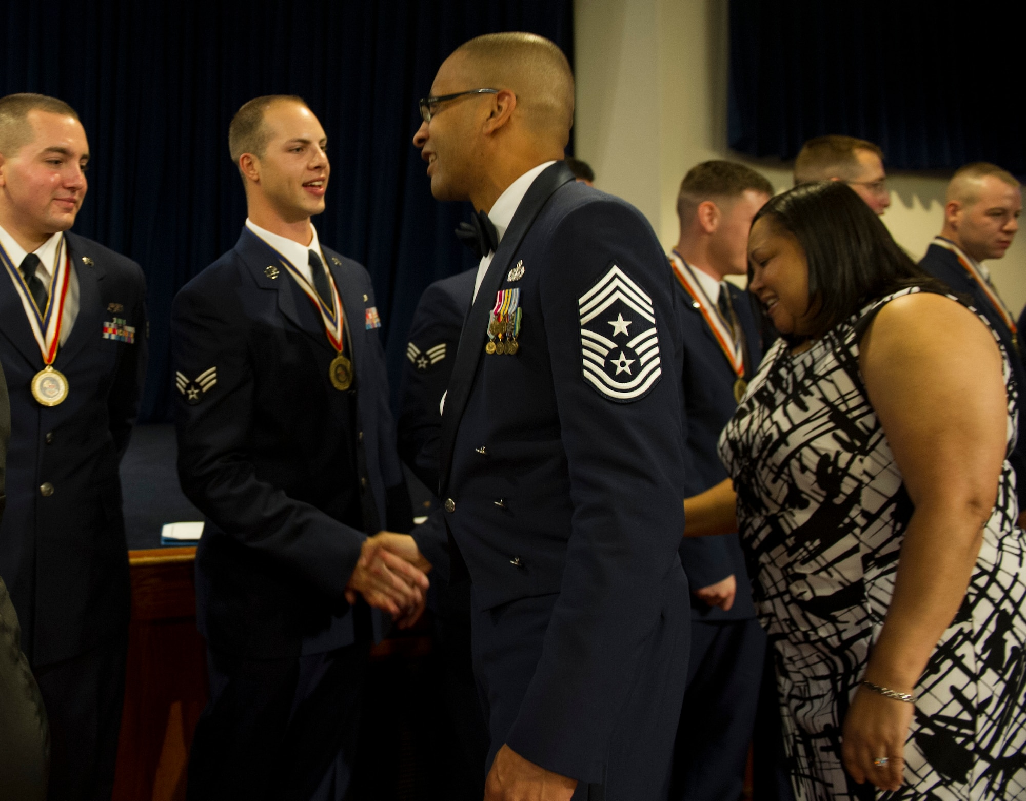 YOKOTA AIR BASE, Japan -- Chief Master Sgt. Ronald Draper, left, 374th Airlift wing command chief, and his wife, Belinda, shake hands with Airmen at the end of their Airman Leadership School Class 12-G graduation ceremony at Yokota Air Base, Japan, Oct. 18, 2012. (U.S. Air Force photo by Senior Airman Andrea Salazar)