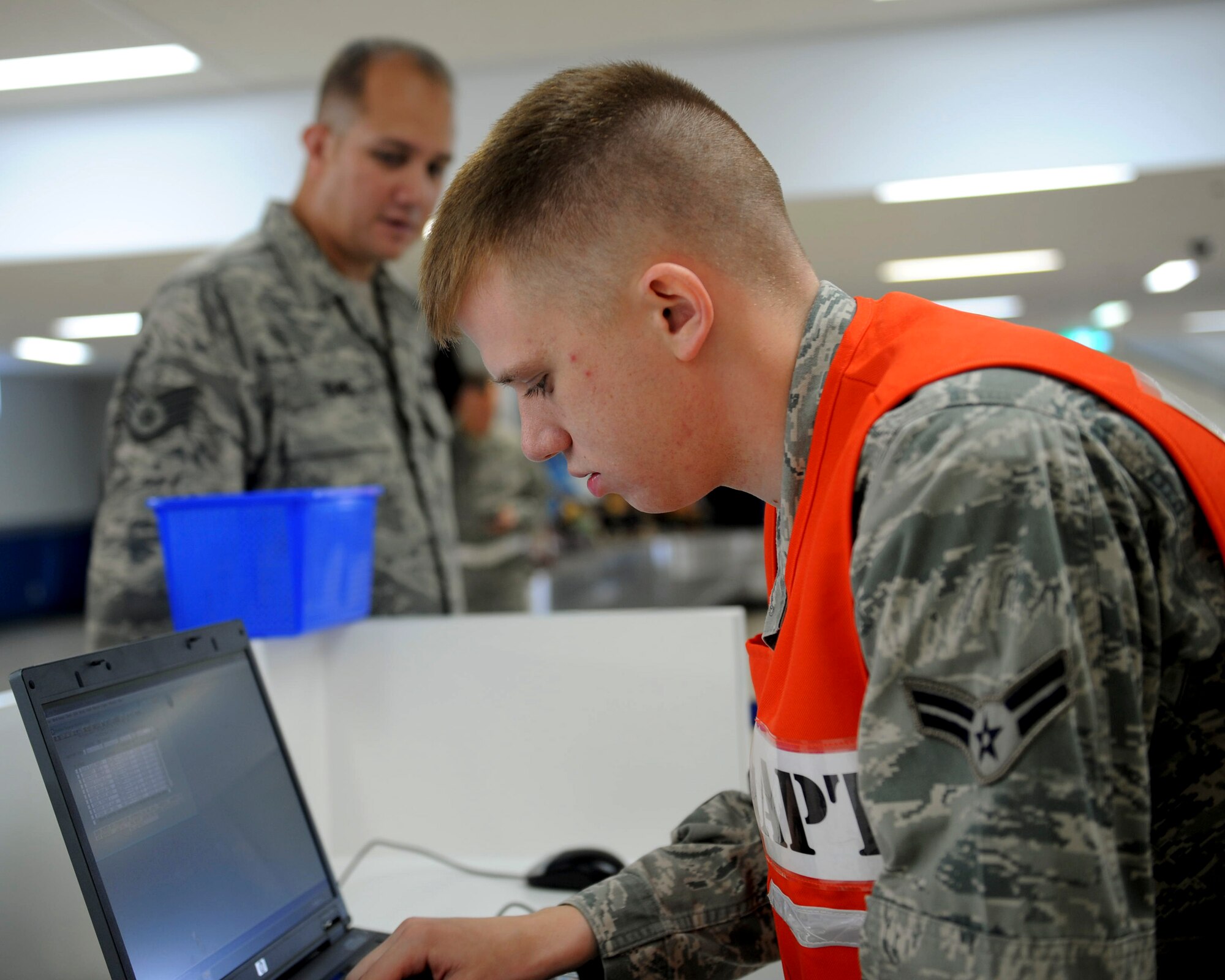 U.S. Air Force Airman 1st Class John Richardson, 18th Logistic Readiness Squadron passenger travel clerk, records information from Staff Sgt. Richard Duwel, 18th Maintenance Operation Squadron weapons controller, during a deployment processing line on the second day of a Pacific Air Forces readiness inspection on Kadena Air Base, Japan, Oct. 23, 2012. The readiness inspection, which began earlier this week, tested the 18th Wing on its ability to survive and operate during a contingency operation. (U.S. Air Force photo/Airman 1st Class Hailey R. Davis)