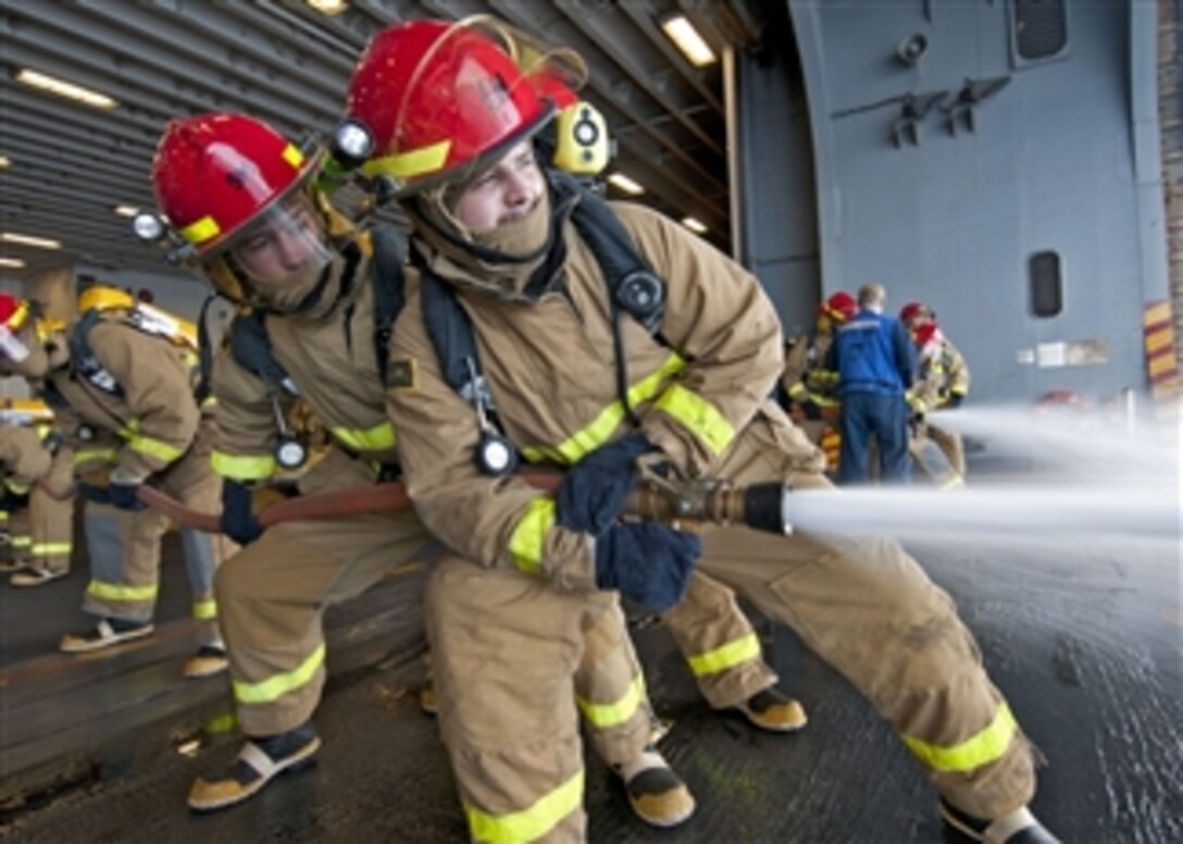 U.S. Navy Petty Officer 3rd Class Jordan Crouse aims a fire hose on a simulated fire during a general quarters drill aboard the amphibious assault ship USS Iwo Jima (LHD 7) as the ship operates in the Gulf of Aden on Oct. 17, 2012.  The Iwo Jima Amphibious Ready Group and the embarked 24th Marine Expeditionary Unit are deployed in support of maritime and theater security operations in the U.S. 5th Fleet area of responsibility.  