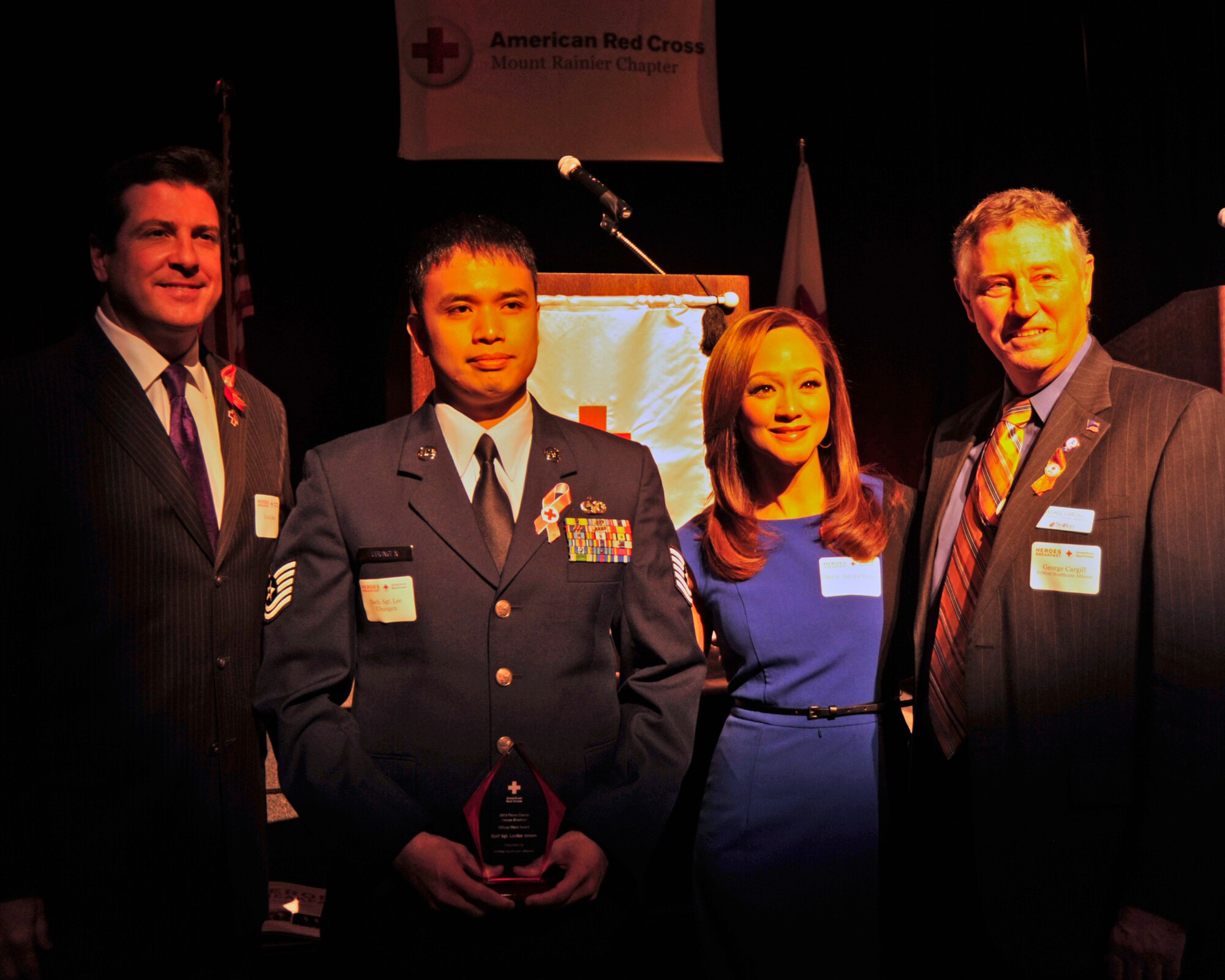 Tech. Sgt. Lee Ubungen, 62nd Aerial Port Squadron air terminal operations center senior controller, stands with (from left to right) David Rose, Q13 Fox News anchor, Maria Arcega-Dunn, Q13 Fox News anchor, and George Cargill, TriWest Healthcare Alliance Northwest vice president, Oct. 24, 2012, during the 2012 American Red Cross Pierce County Heroes Breakfast in Tacoma, Wash. Jensen accepted the "Military Hero Award" on behalf of Staff Sgt. Landon Jensen, 62nd APS ramp services supervisor, who earned the award for saving a woman from a burning car last year. (U.S. Air Force photo/Staff Sgt. Frances Kriss)