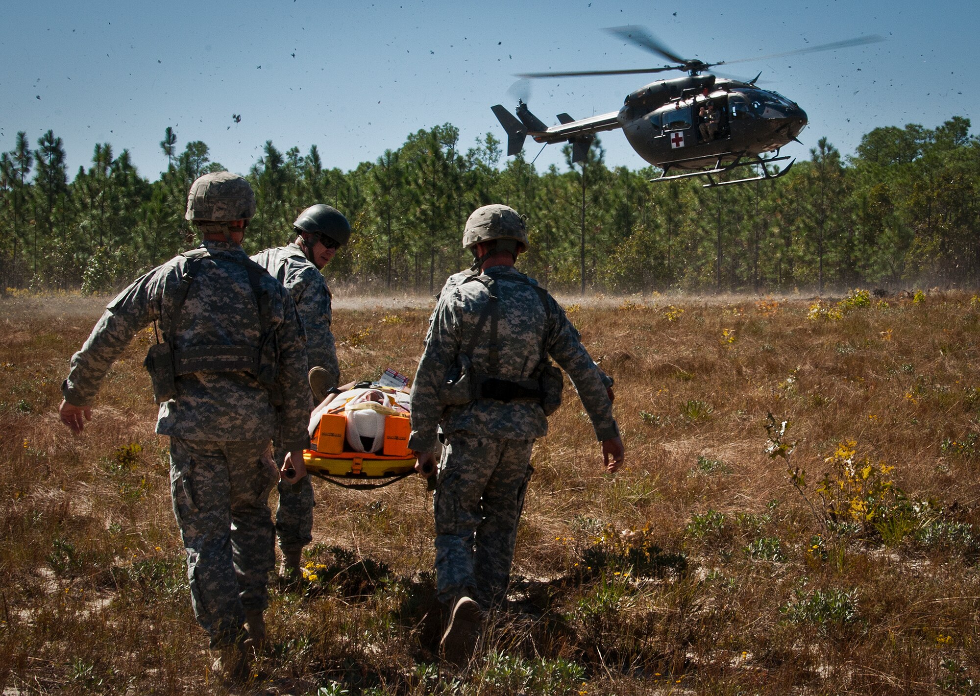 Soldiers carry a simulated victim to the helicopter for medical evacuation during a downed aircraft exercise on the Eglin range, Oct. 20.  The 6th Ranger Training Battalion, Team Eglin’s emergency responders and local medical facilities participated in the exercise that simulated a helicopter crash with 12 Soldiers injured deep within the Eglin range.  The victims were either evacuated by helicopter or by ambulance to area hospitals.  The annual exercise was to validate the battalion’s emergency procedures and test their communication with Team Eglin and local emergency and medical units.  (U.S. Air Force photo/Samuel King Jr.)