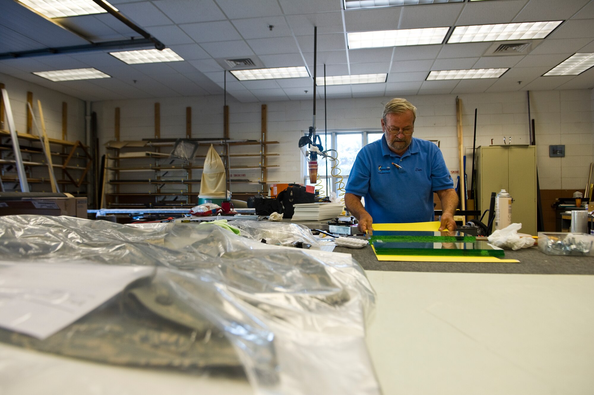 Dan Ruddell, manager of The Frame Shop, picks out glass to place in a custom frame design he is working on at the Frame Shop on Hurlburt Field, Fla., Oct. 12, 2012. The shop comes equipped with metal and wood frames in a large selection of materials and colors, foam-core back-boards, frame hardware and a variety of glass which includes standard and non-glare glass. U.S. Air Force photo/Airman 1st Class Christopher Williams)
