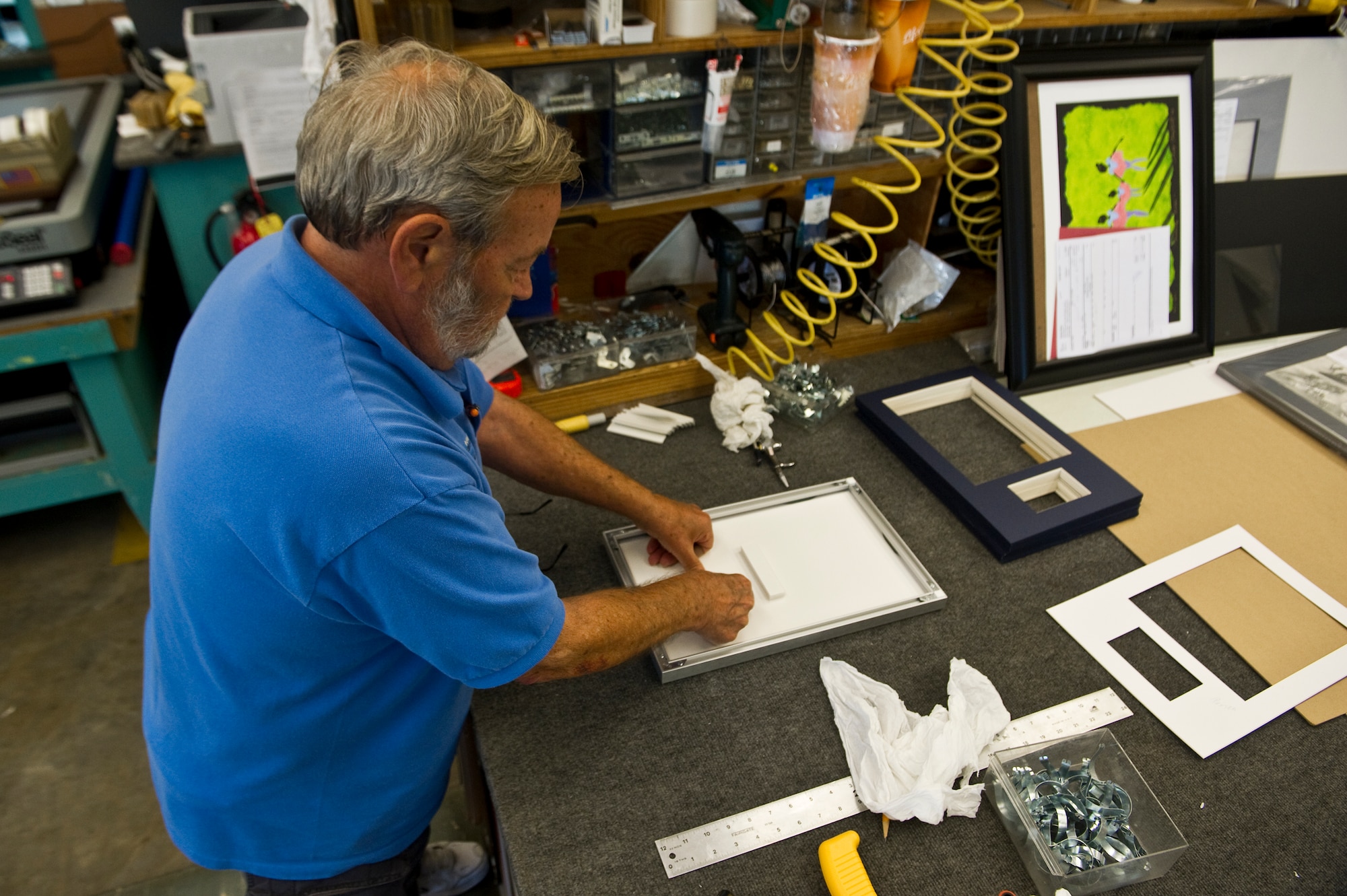Dan Ruddell, manager of The Frame Shop, places a spacer between two foam boards while working on a custom frame at The Frame Shop on Hurlburt Field, Fla., Oct. 12, 2012. The shop has a typical turnaround time of two weeks on special custom designs. (U.S. Air Force photo/Airman 1st Class Christopher Williams)

