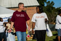 Lt. Col. David Schlevensky, 628th Medical Support Squadron commander, walks Traci James, warehouse production technician, towards the clothing racks during the Department of Veterans Affairs Annual Stand Down Against Homelessness, Oct. 19, 2012, at the North Charleston Armory. Members of the U.S. Air Force and U.S. Navy from Joint Base Charleston volunteered their time at the event, along with members of the U.S. Coast Guard Sector Charleston. James is a former U.S. Army satellite and radar missile systems repair technician. (U.S. Air Force photo/Airman 1st Class George Goslin)