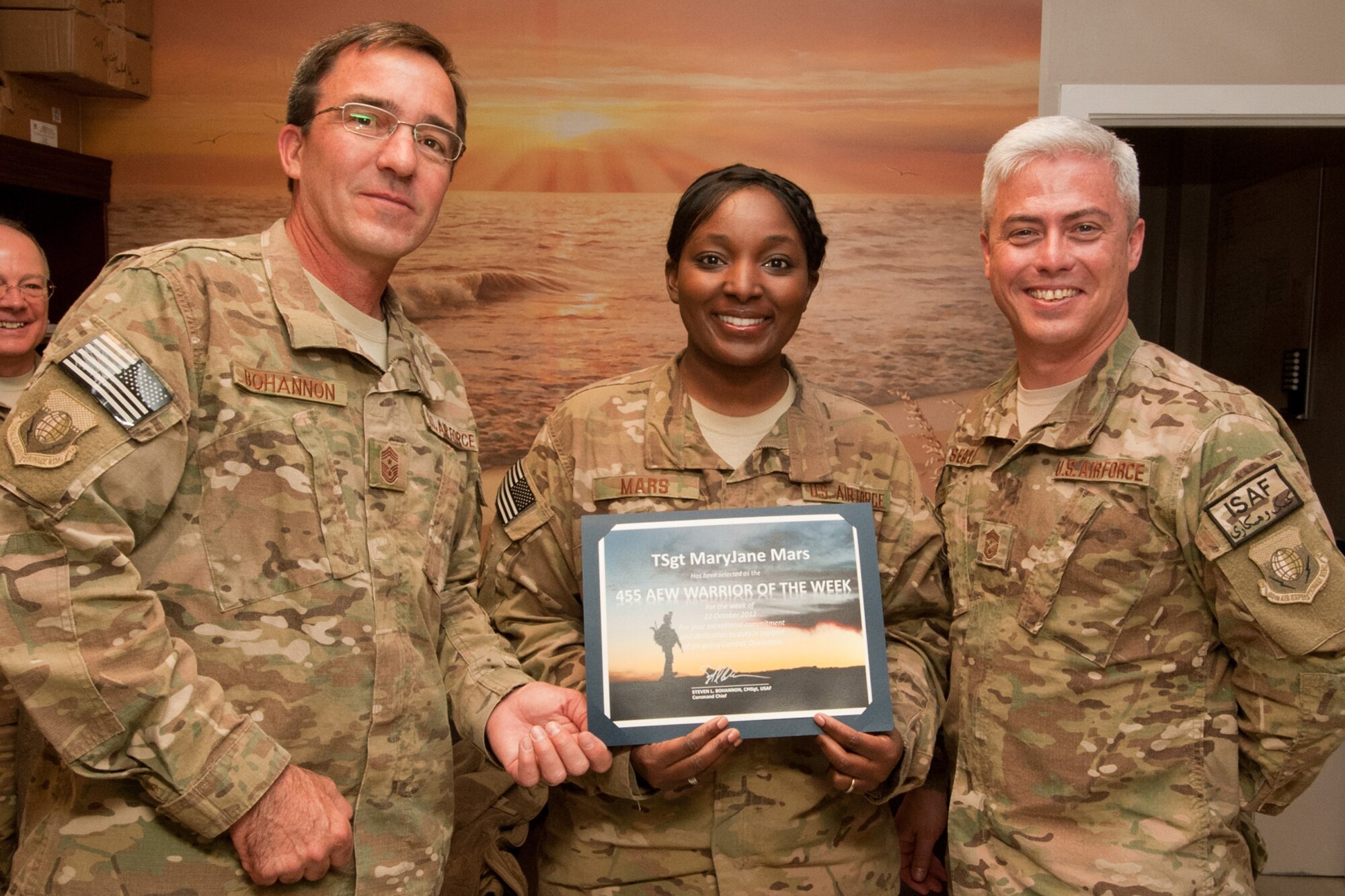 Chief Master Sgt. Steve Bohannon (left), 455th Air Expeditionary Wing command chief, and Chief Master Sgt. Robert Sealey (right), U.S. Air Force Central Command command chief present the Warrior of the Week award to Tech. Sgt. MaryJane Mars, a chaplain’s assistant assigned to the 455th Air Expeditionary Wing Head Chaplain at Bagram Airfield Afghanistan, Oct. 24, 2012. Mars provides crisis intervention counseling to members of the 455th Expeditionary Security Forces Squadron. Additionally, she supports the Bagram Office of Special Investigations. (U.S. Air Force photo/Staff Sgt. Jeff Nevison)