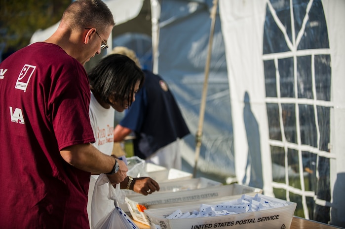 Lt. Col. David Schlevensky, 628th Medical Support Squadron commander, assists Traci James, warehouse production  technician, in getting a pill organizer during the Department of Veterans Affairs Annual Stand Down Against Homelessness Oct. 19, 2012, at the North Charleston Armory. Members of the U.S. Air Force and U.S. Navy from Joint Base Charleston volunteered their time at the event, along with members of the U.S. Coast Guard Sector Charleston. James is a former U.S. Army satellite and radar missile systems repair technician. (U.S. Air Force photo/Airman 1st Class George Goslin)