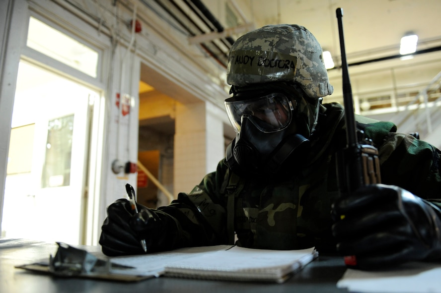 U.S. Air Force Master Sgt. Audy Doctora updates the facility events log in Mission-Oriented Protective Posture gear following a simulated attack on the base as part of Exercise Beverly Bearcat 12-1, an operational readiness inspection on Kadena Air Base, Japan, Oct. 24, 2012. Doctora is the 18th Force Support Squadron Mortuary Affairs night shift supervisor. Though Kadena doesn’t normally accommodate mortuary affairs, during contingency operations, the 18th FSS establishes a mortuary on base to provide quicker response following an attack. (U.S. Air Force photo/Senior Airman Maeson L. Elleman)