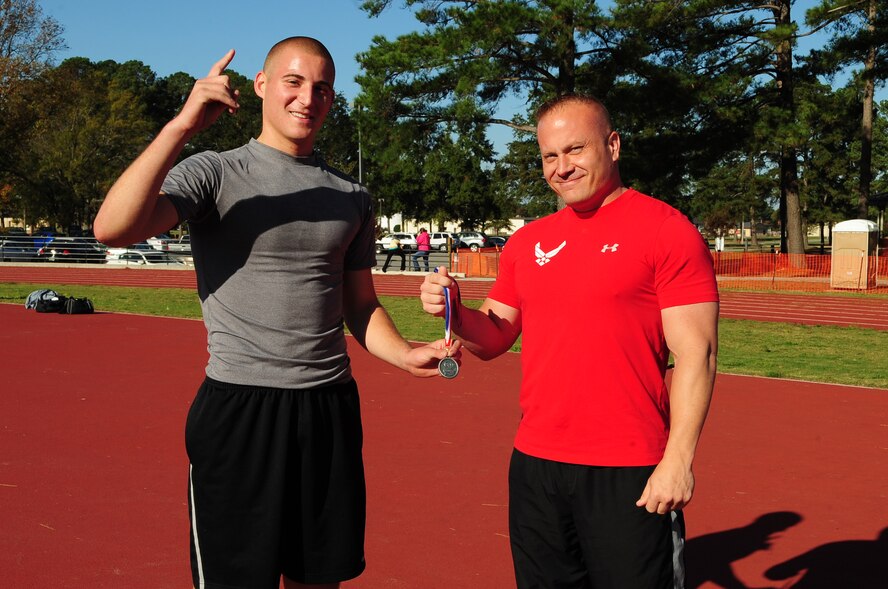 U.S. Air Force Airman 1st Class Tyler Copeland, 333rd AMU assistant dedicated crew chief, receives a medal from Mike Unden, 4th Force Support Squadron military fitness specialist, after the Combat Fitness Challenge on Seymour Johnson Air Force Base, N.C., Oct. 20, 2012. Copeland finished a close second in the challenge with a time of 27:20. (U.S. Air Force photo/Airman 1st Class Aubrey White/Released)