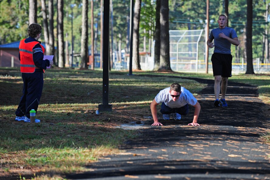 U.S. Air Force Staff Sgt. Brendan Manley-Bryant, 333rd Aircraft Maintenance Unit dedicated crew chief, performs pushups as Airman 1st Class Tyler Copeland, 333rd AMU assistant dedicated crew chief, catches up to him during the Combat Fitness Challenge on Seymour Johnson Air Force Base, N.C., Oct. 20, 2012. Manley-Bryant and Copeland were in a neck and neck competition during the challenge and finished within seconds of one another. (U.S. Air Force photo/Airman 1st Class Aubrey White/Released)