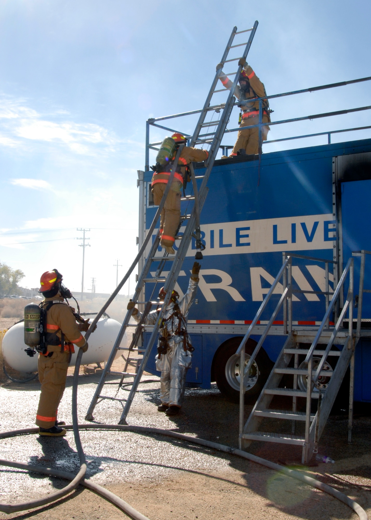 Firefighters prepare to enter a mobile live fire trainer provided by North Tree Fire International when the Edwards Fire Department gathered together Oct.18 for structural fire training, which is required every six months. (U.S. Air Force Photo by Laura Mowry)