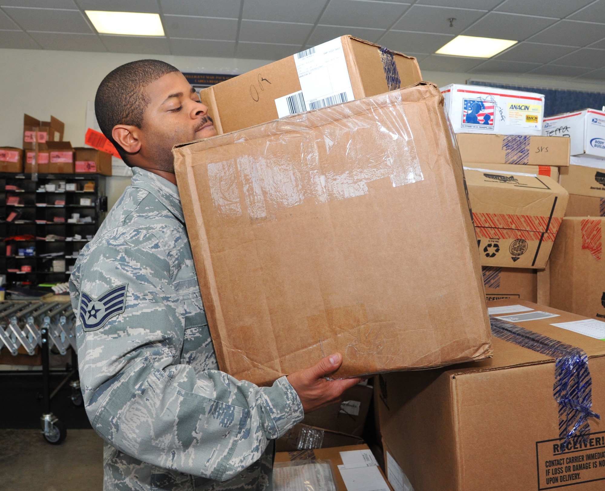Staff Sgt. Keefer Neal, 65th Communications Squadron Postal Clerk stocks the shelves with packages after they are unloaded from the truck at the Lajes Field Post Office on Oct. 23, 2012.The Post Office handles an average of 800 packages a week. The Physical Therapy office ensures postal clerks have perfect technique to limit the amount of work related injuries. 