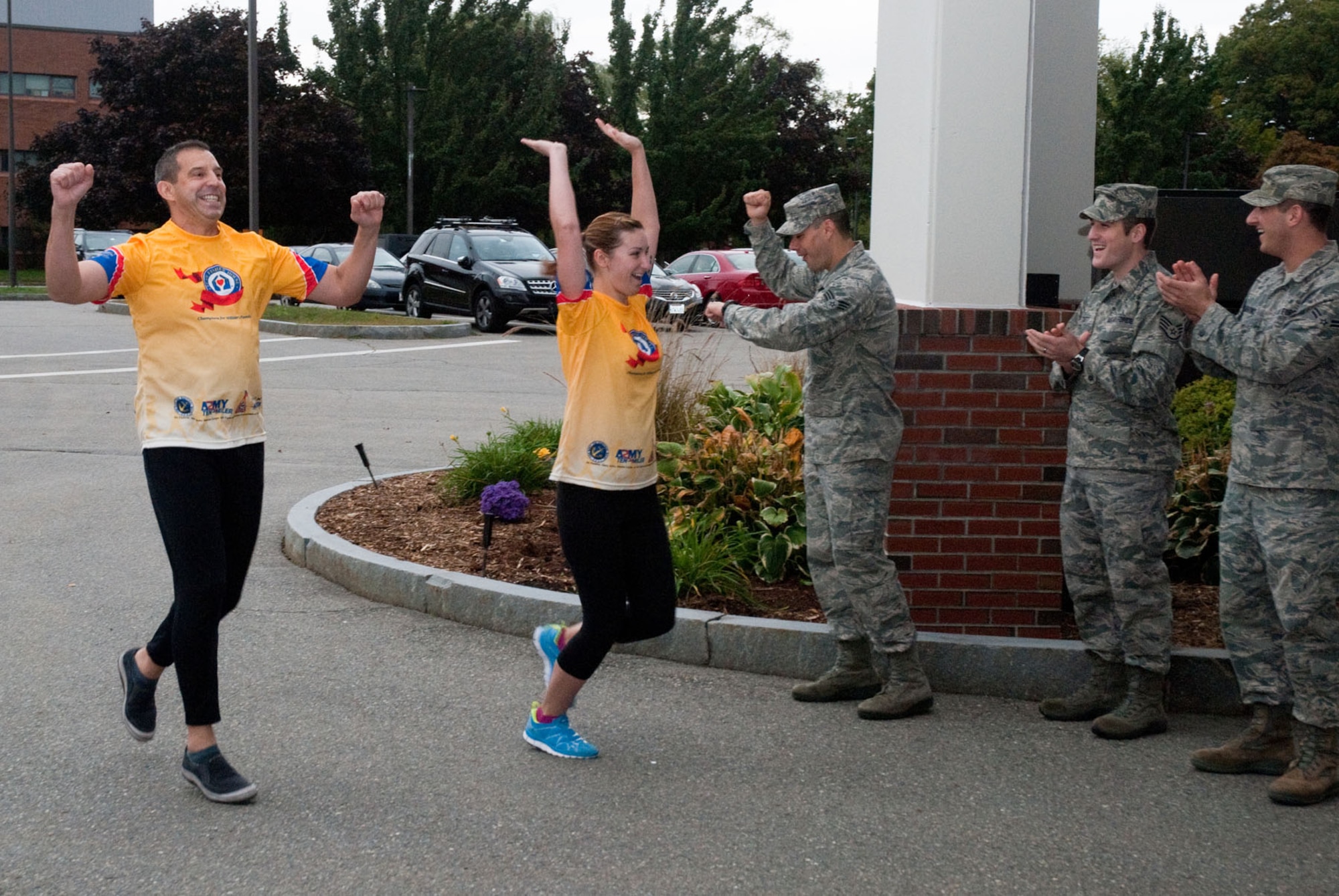 HANSCOM AIR FORCE BASE, Mass. –   (from left to right) Army Lt. Col. Paul Garcia and Senior Airman Michelina Bonavito finish a training run as teammates Senior Airman Dennis Cooke, Staff Sgt. Justin Beckett and Airman 1st Class Thomas Membrino cheer them on. The five team members, plus 1st Lt. Mallory Morgan, will run the U.S. Marine Corps Marathon and 10K for the Fisher House Foundation Oct. 28. (U.S. Air Force photo by Mark Herlihy)