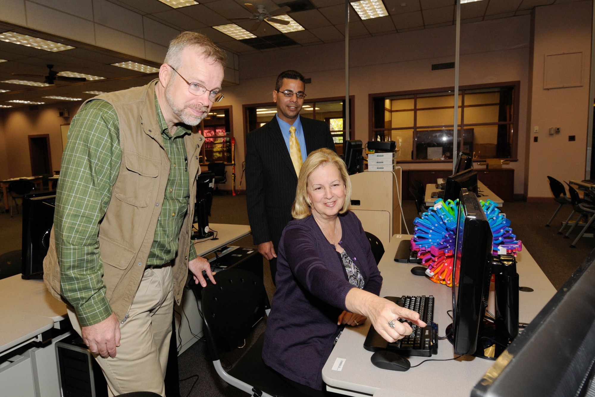 HANSCOM AIR FORCE BASE, Mass. – Barbara Koscak, STARBASE co-founder, creator and director, points to information on a computer as Dr. Peter Holden (left), Hanscom STARBASE director, and Steve Ramos, 66th Force Support Squadron Force Development Flight chief, stand by. The Department of Defense initiative on science, technology, engineering and math will begin teaching fifth grade students in the old library facility next month. (U.S. Air Force photo by Linda LaBonte Britt)