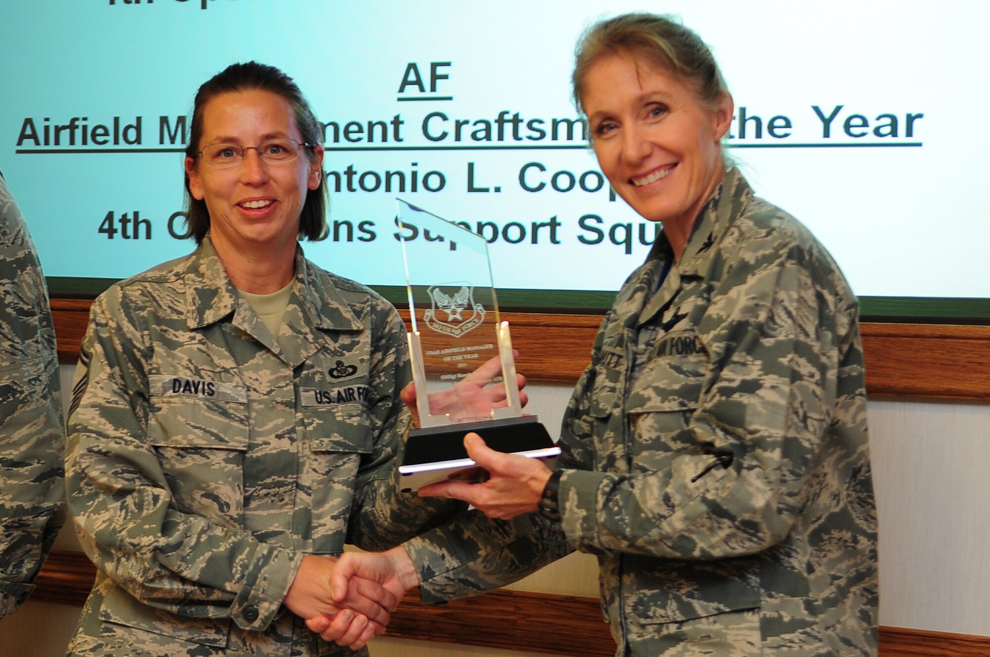 U.S. Air Force Senior Master Sgt. Ronda Davis, 4th Operations Support Squadron airfield manager, accepts an award from Col. Jeannie Leavitt, 4th Fighter Wing commander, during a meeting on Seymour Johnson Air Force Base, N.C., Oct. 16, 2012. Davis was recognized as the Air Force airfield manager of the year for 2011. (U.S. Air Force photo/Airman 1st Class Aubrey White/Released)