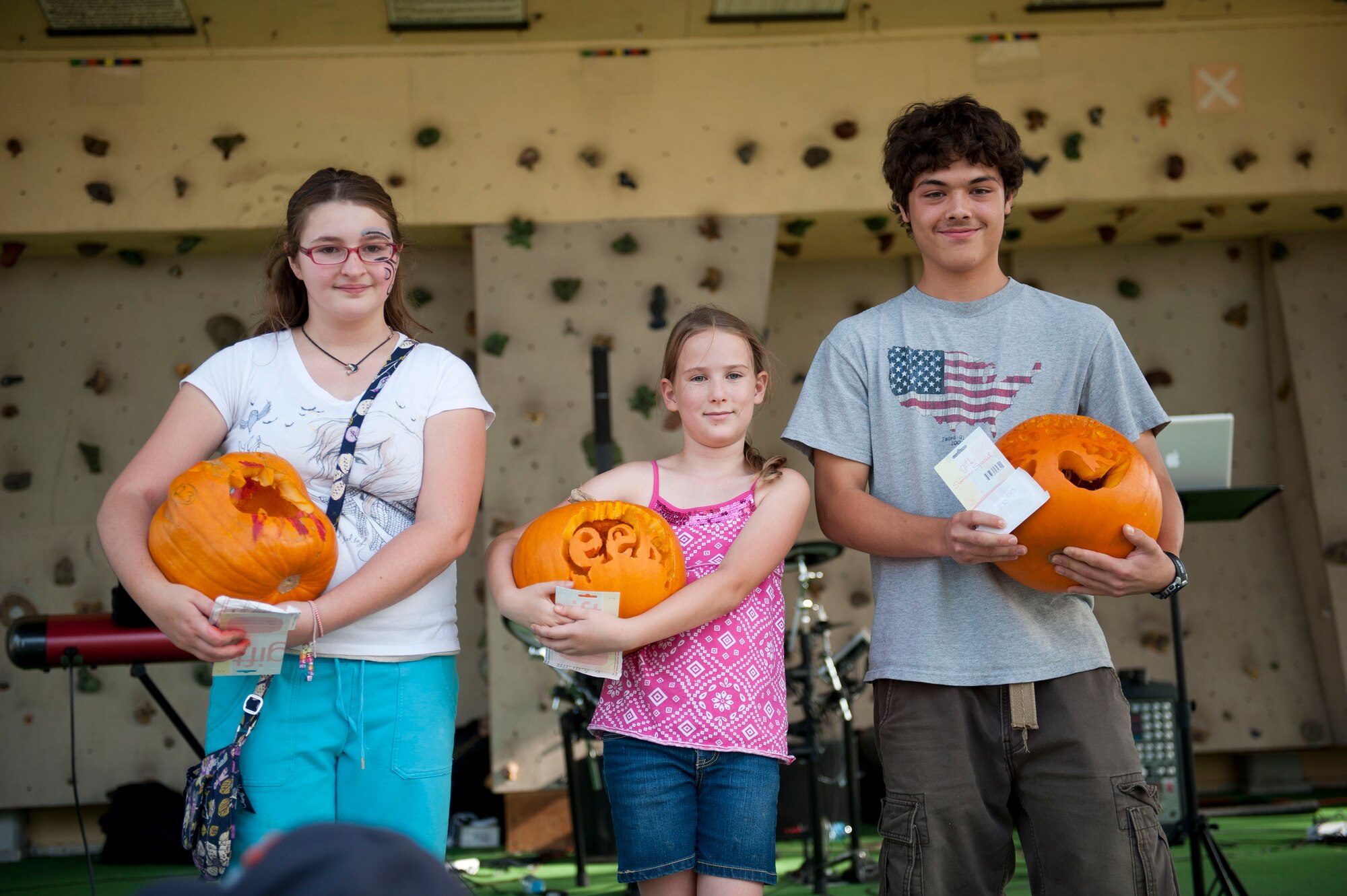 Contestants hold the top three pumpkins from the pumpkin carving contest during Fall Fest Oct. 20, 2012, at Incirlik Air Base, Turkey.  Each contestant got to take their pumpkin home and the winners of the contest received Army and Air Force Exchange Service gift cards. (U.S. Air Force photo by Senior Airman Clayton Lenhardt/Released)