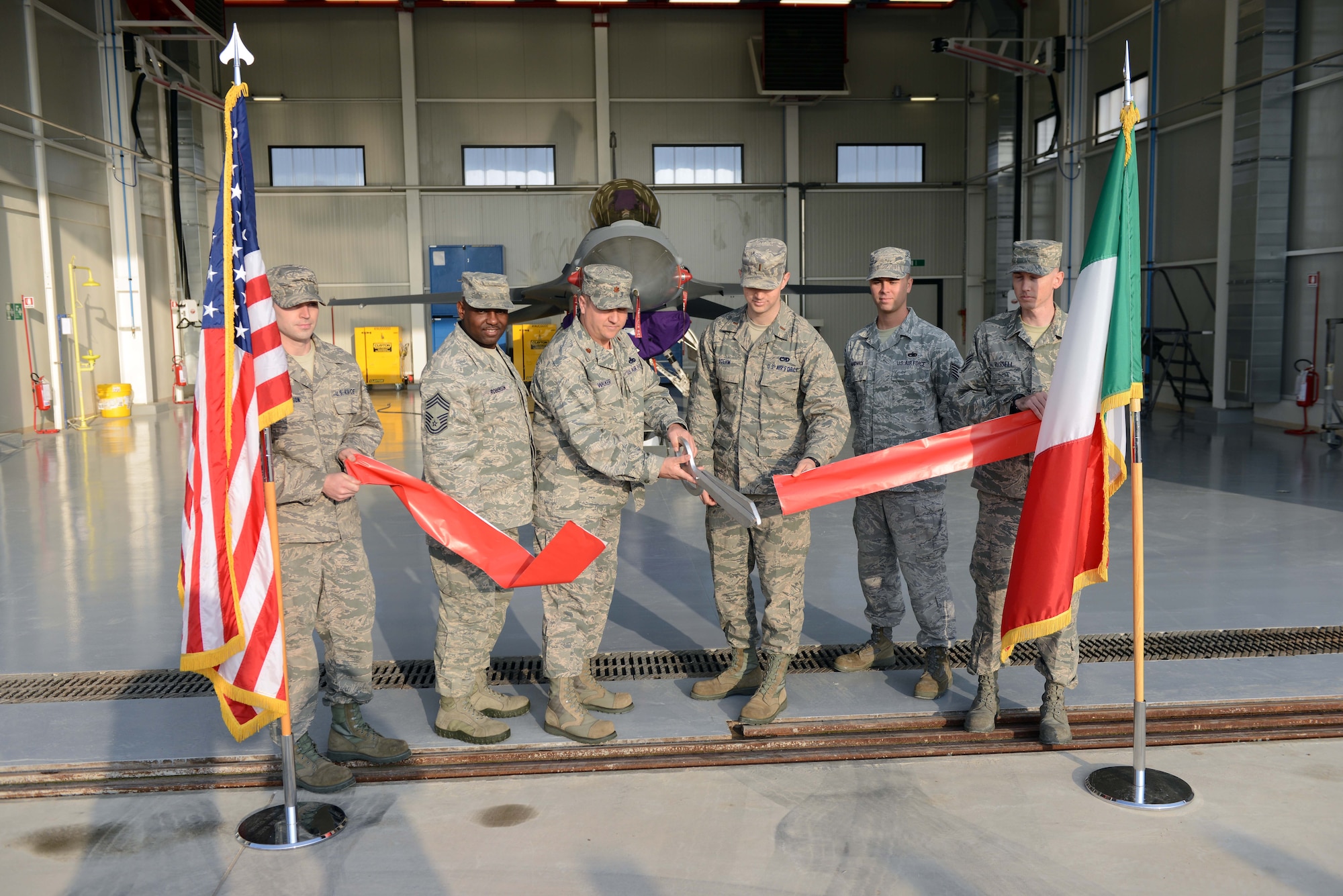 Airmen from the 31st Maintenance Squadron cut the ribbon during a ribbon cutting of the new Corrosion Control Facility Oct. 19. The new facility will save the 31st Fighter Wing $32,000 per jet, with the ability to painting the jets locally versus sending them on temporary duty to be painted at alternative locations. (U.S. Air Force photo/Staff Sgt. Justin Weaver)