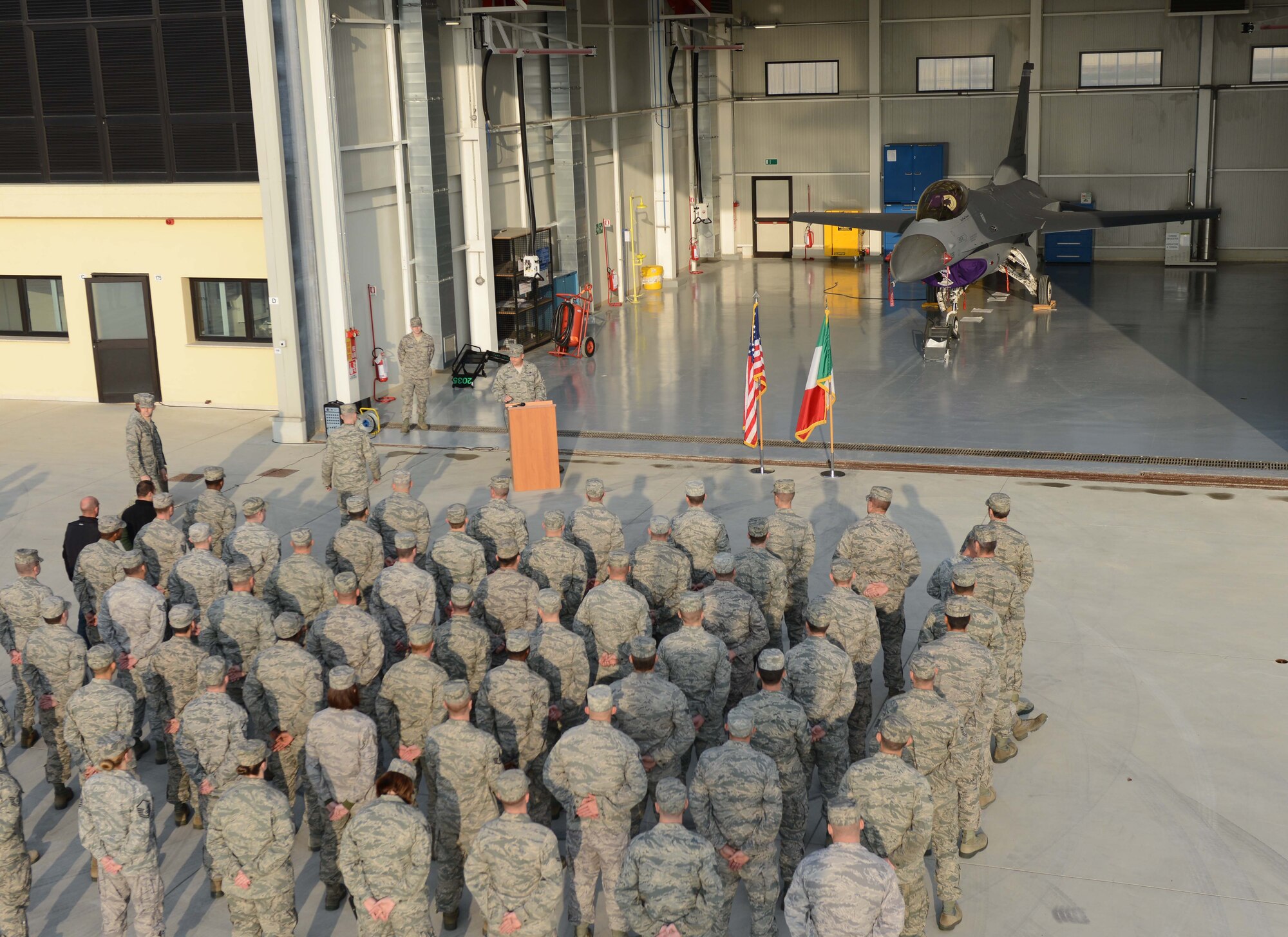 Airmen attend the ribbon cutting of the new Corrosion Control Facility Oct. 19 at Aviano Air Base, Italy. The new facility will allow personnel assigned to the Aircraft Structural Maintenance Corrosion Control section the ability to conduct all aspects of corrosion control and treatment, to include sanding, media blasting of small parts, and full painting and stenciling. (U.S. Air Force photo/Staff Sgt. Justin Weaver)
