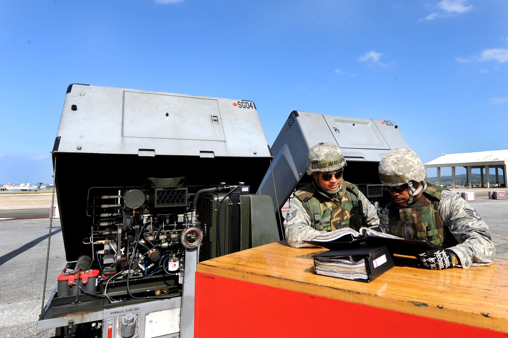 U.S. Air Force Staff Sgts. Alexis Gandia-Salgado and Eugene Lofton, 18th Equipment Maintenance Squadron aircraft ground equipment craftsmen, review technical orders before fixing two self-generating nitrogen carts during a Pacific Air Forces readiness inspection on Kadena Air Base, Okinawa, Oct. 24, 2012. AGE’s mission is to support the flight line with ground equipment and help generate equipment. They also perform inspections on 1,100 pieces of equipment base-wide. (U.S. Air Force photo/Airman 1st Class Brooke P. Beers)