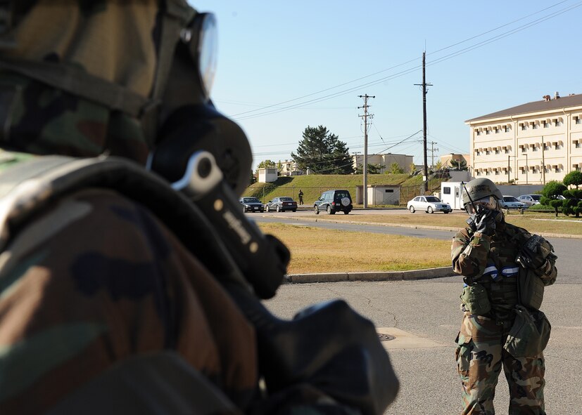 Senior Airman Troy Massey, 8th Mission Support Group, tells Staff Sgt. Virginia Garcia, 8th Force Support Squadron, about possible contamination during a Post-Attack Reconnaissance Team sweep on Kunsan Air Base, Republic of Korea, Oct. 18, 2012. This was part of a simulated post-attack scenario during exercise Beverly Midnight 13-1, which was designed to assess the ability of base personnel to perform appropriate PAR sweeps and report possible contamination. (U.S. Air Force photo/Staff Sgt. Jonathan Fowler)