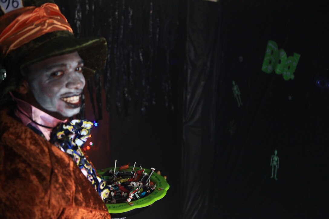 A Marine with Combat Logistics Regiment 27, 2nd Marine Logistics Group dressed as the Mad Hatter waited with a bowl of candy near the exit of the unit’s haunted house aboard Camp Lejeune, N.C., 2012. Volunteers set up the haunted house over the course of a week and hosted a barbecue for the regiment’s families.