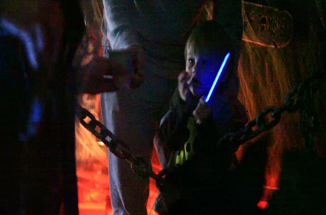 A child recoils at the sight of a witch inside Combat Logistics Regiment 27, 2nd Marine Logisitics Group’s haunted house aboard Camp Lejeune, N.C., Oct. 21, 2012. Each of the children received a glow-in-the-dark bracelet to ward off the evils inside the house and keep them safe from any dangers. 