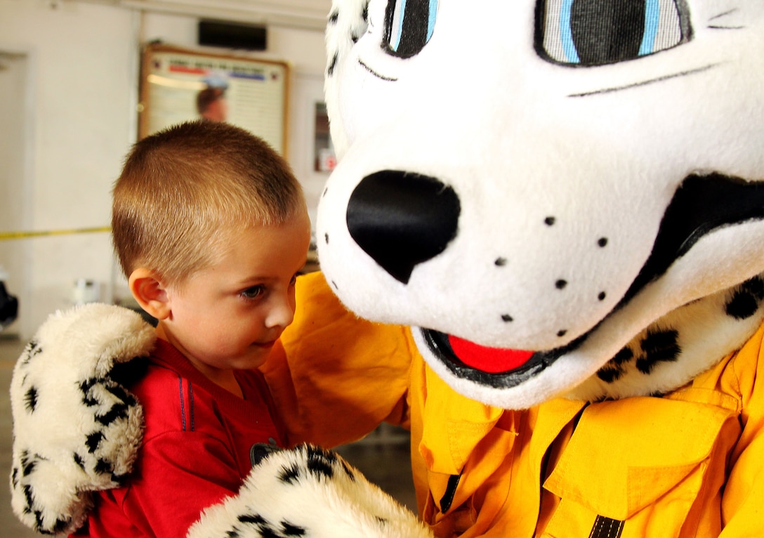 Maddox Adcox, 2, hugs Sparky the Fire Dog, official mascot for the National Fire Protection Association at the Combat Center Fire Department Chili Luncheon Oct. 12, 2012.