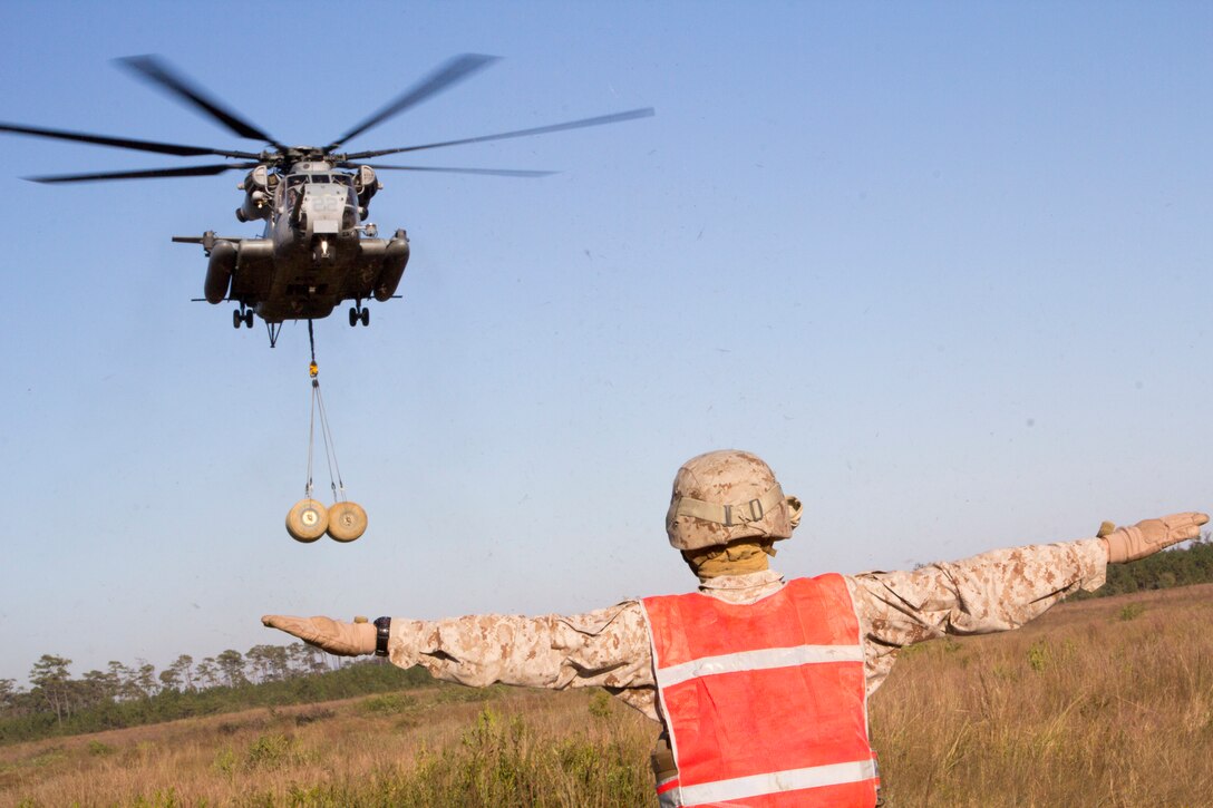 A Marine assigned to Combat Logistics Battalion (CLB) 26, 26th Marine Expeditionary Unit (MEU) conduct helicopter suspension training at Landing Zone Falcon on Camp Lejeune, N.C., October 23, 2012. A CH-53E "Super Stallion" assigned to Marine Medium Tiltrotor Squadron (VMM) 266 Reinforced lifted and dropped two 500 gallon water containers between two different landing zones. The training was conducted as part of 26th MEU's pre-deployment training program. The 26th MEU is slated to deploy in 2013. (U.S. Marine Corps photo by Cpl. Christopher Q. Stone/Released)